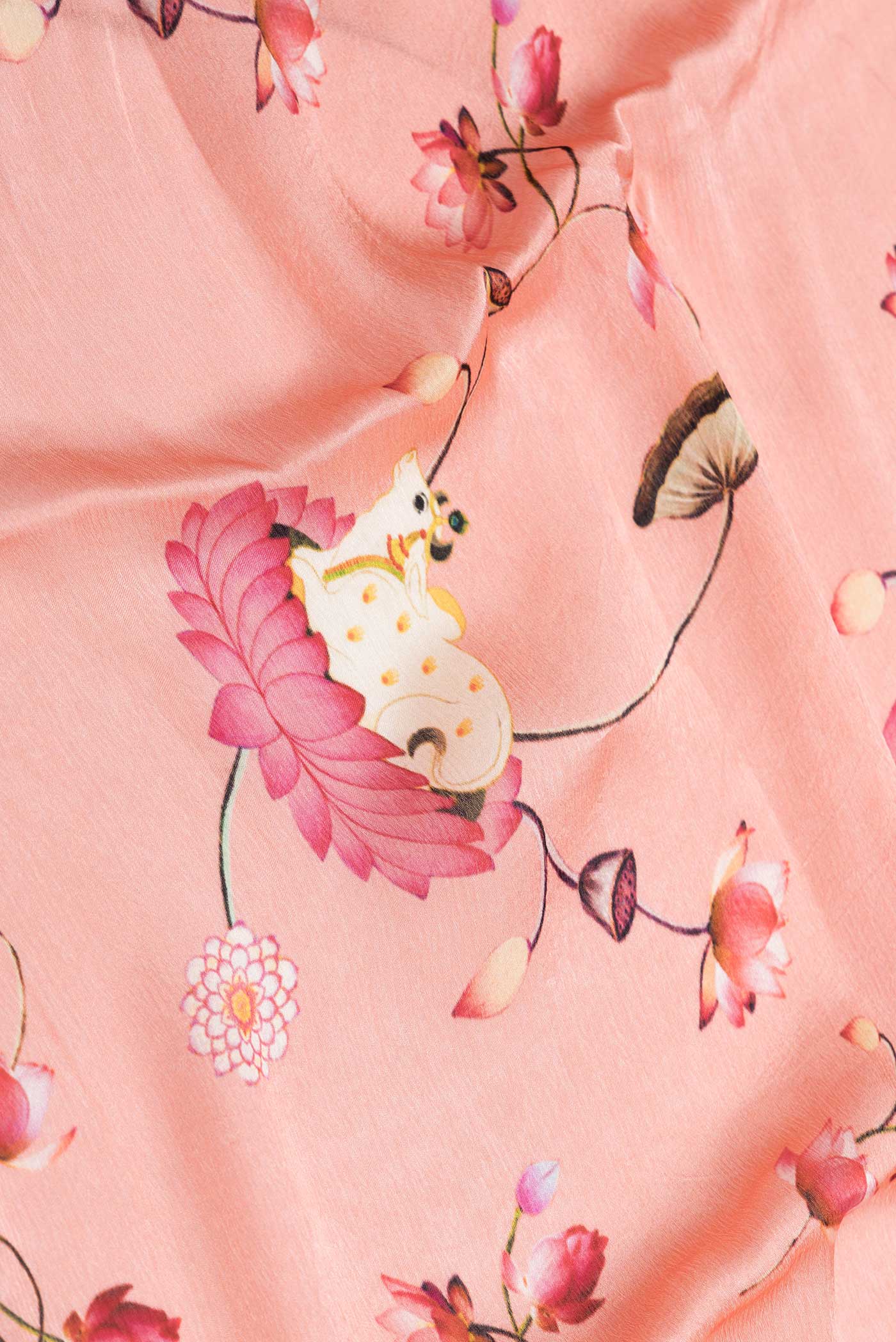 Close up of Peach Dual Tone Mysore Crepe Saree with Printed design on the body and Printed Border displaying folds