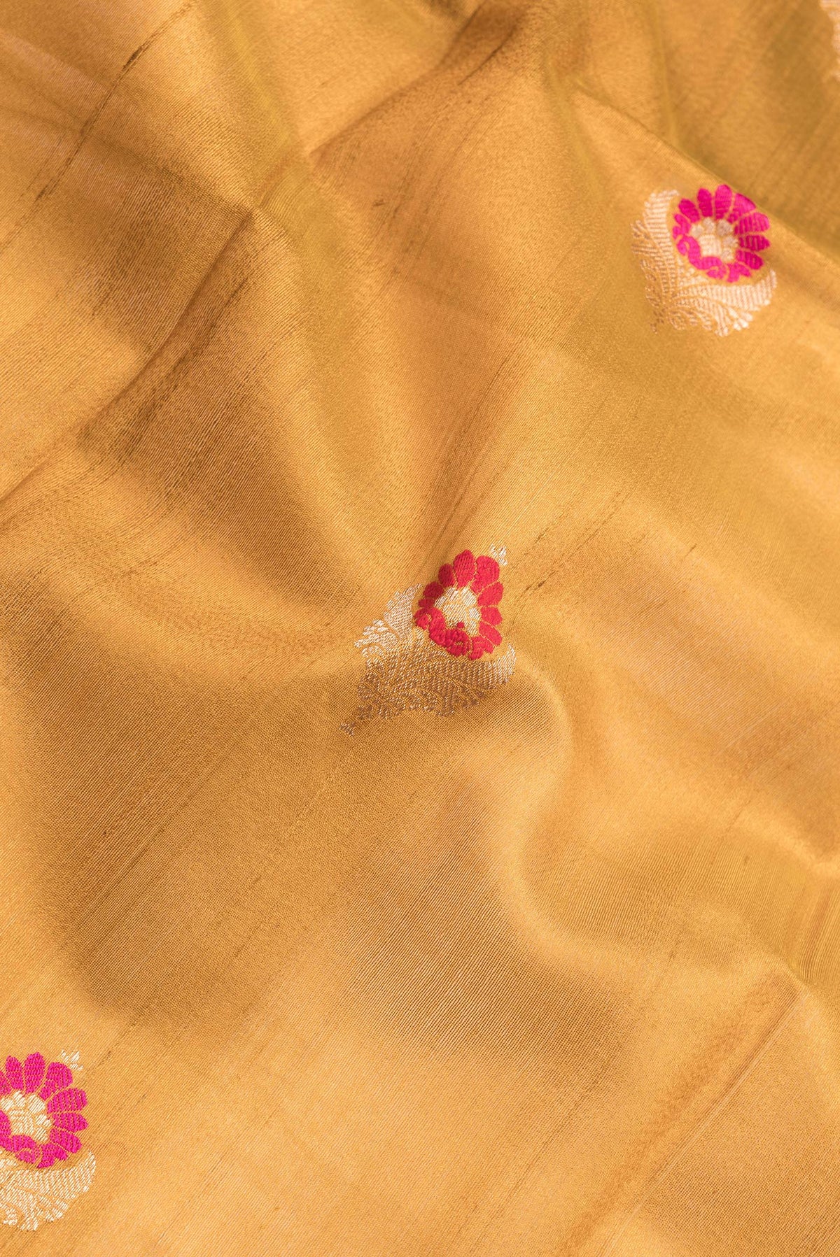 Close up of Mustard Dual Tone Tussar Silk Saree with Zari And Thread Butta on the body and Zari Border.  displaying folds
