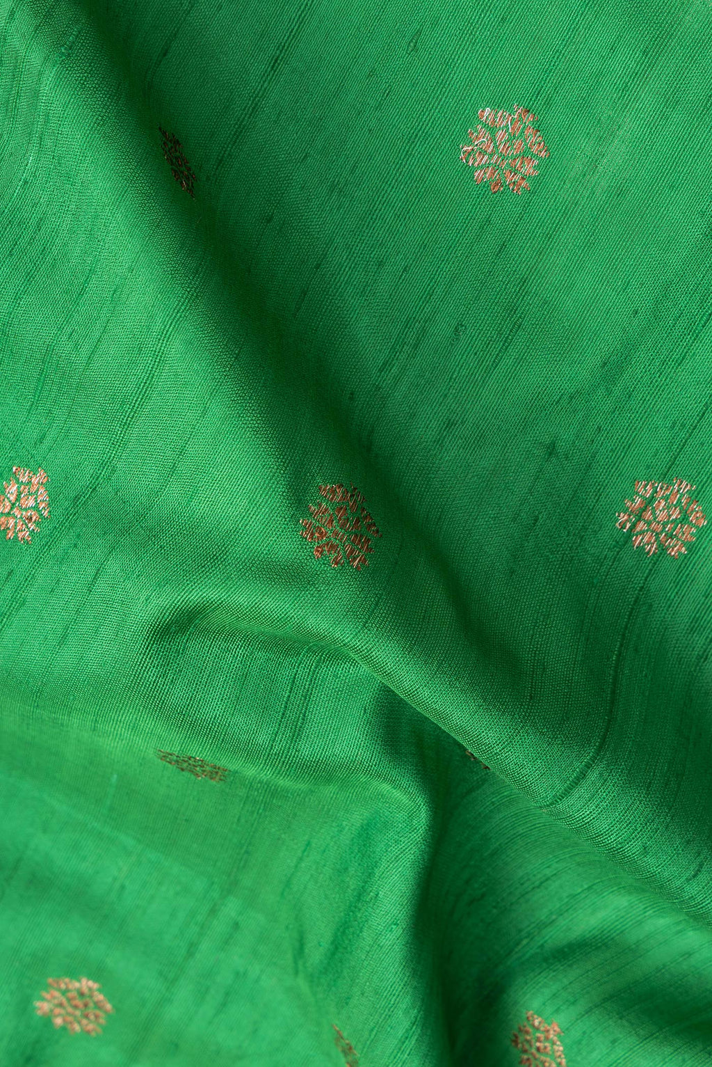 Close up of Green Dual Tone Raw Silk Saree with Zari Butta on the body and Zari Border.  displaying folds