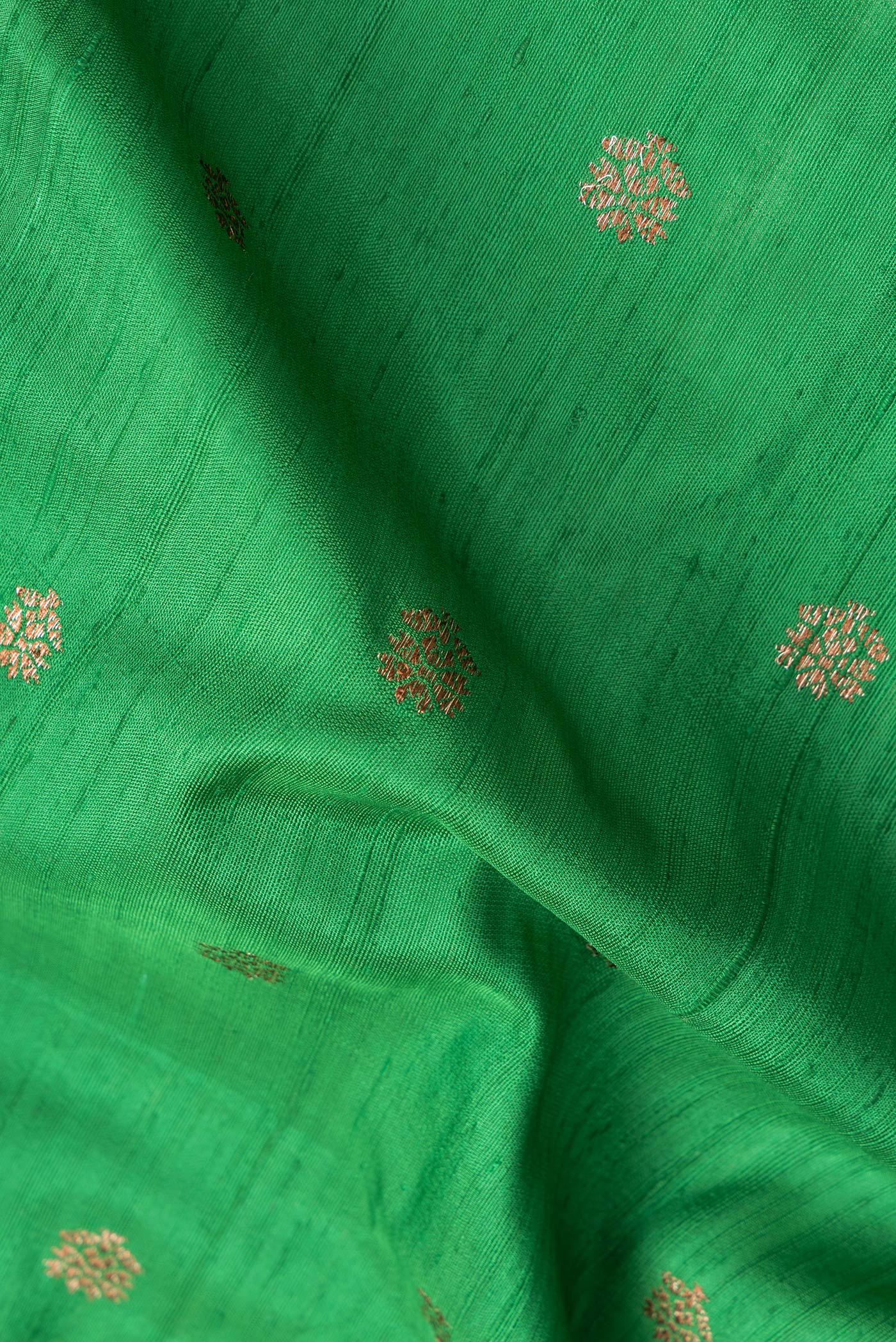 Close up of Green Dual Tone Raw Silk Saree with Zari Butta on the body and Zari Border.  displaying folds