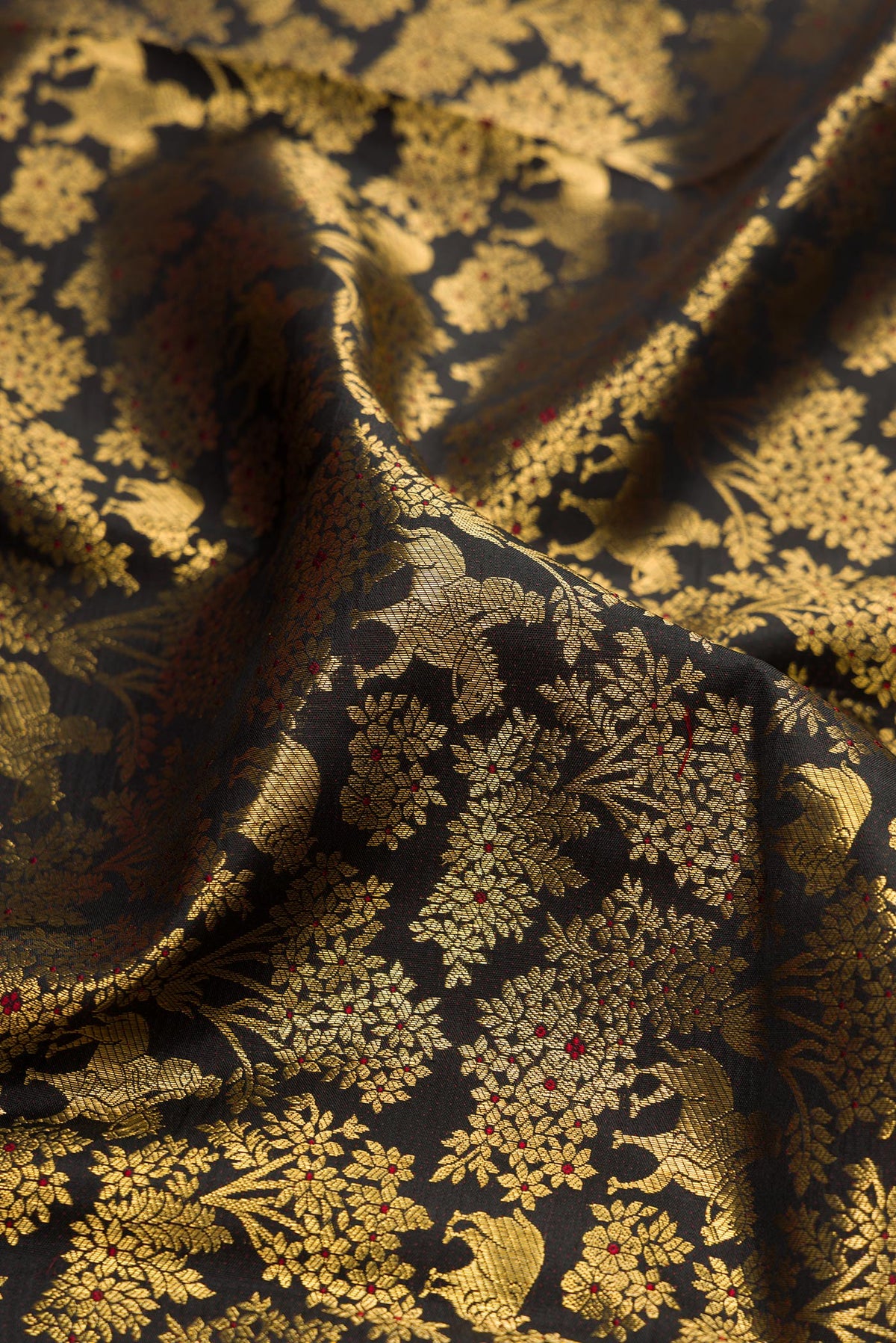 Close up of Black Kanchipuram Silk Saree with Zari Brocade on the body and Zari Border.  displaying folds