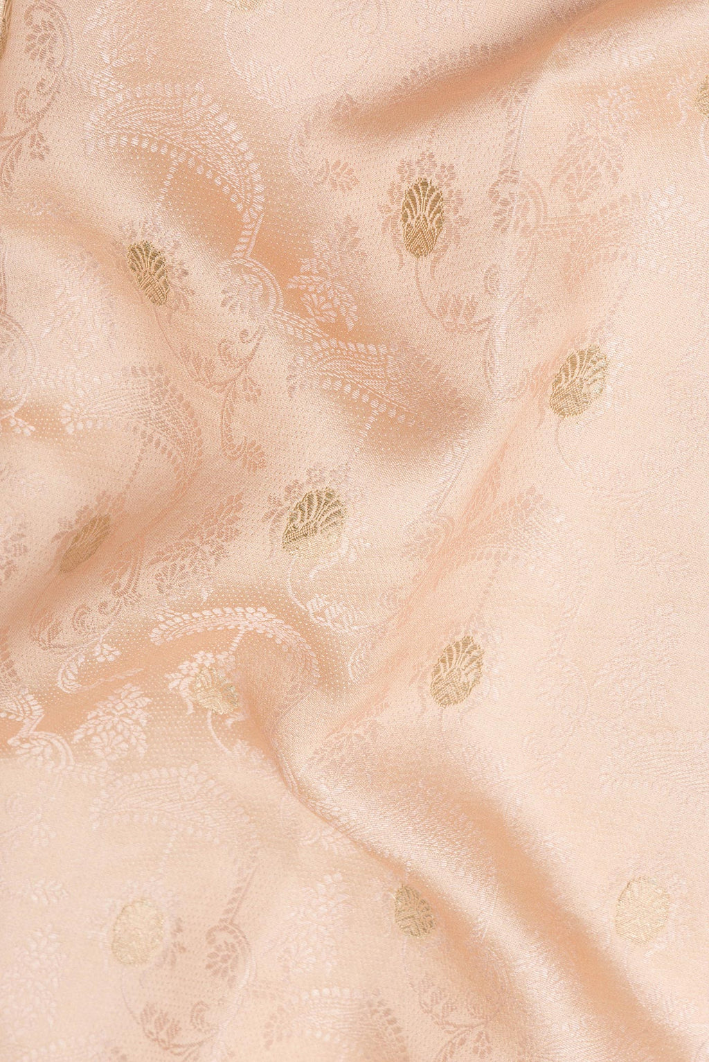 Close up of Peach Tussar Saree with Jacquard With Zari Butta on the body and Fancy Border.  displaying folds