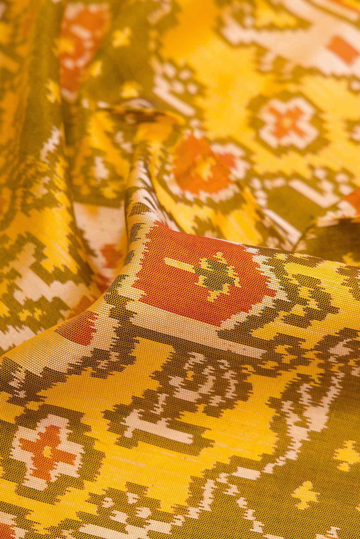 Close up of Mehandi Green Dual Tone Rajkot Patola Silk Saree with Ikat Print on the body and Ikat Border displaying folds