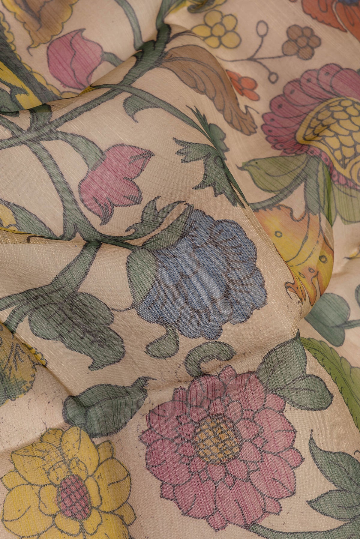 Close up of Rose Gold Organza Silk Saree with kalamkari Print on the body and Thread Border.  displaying folds