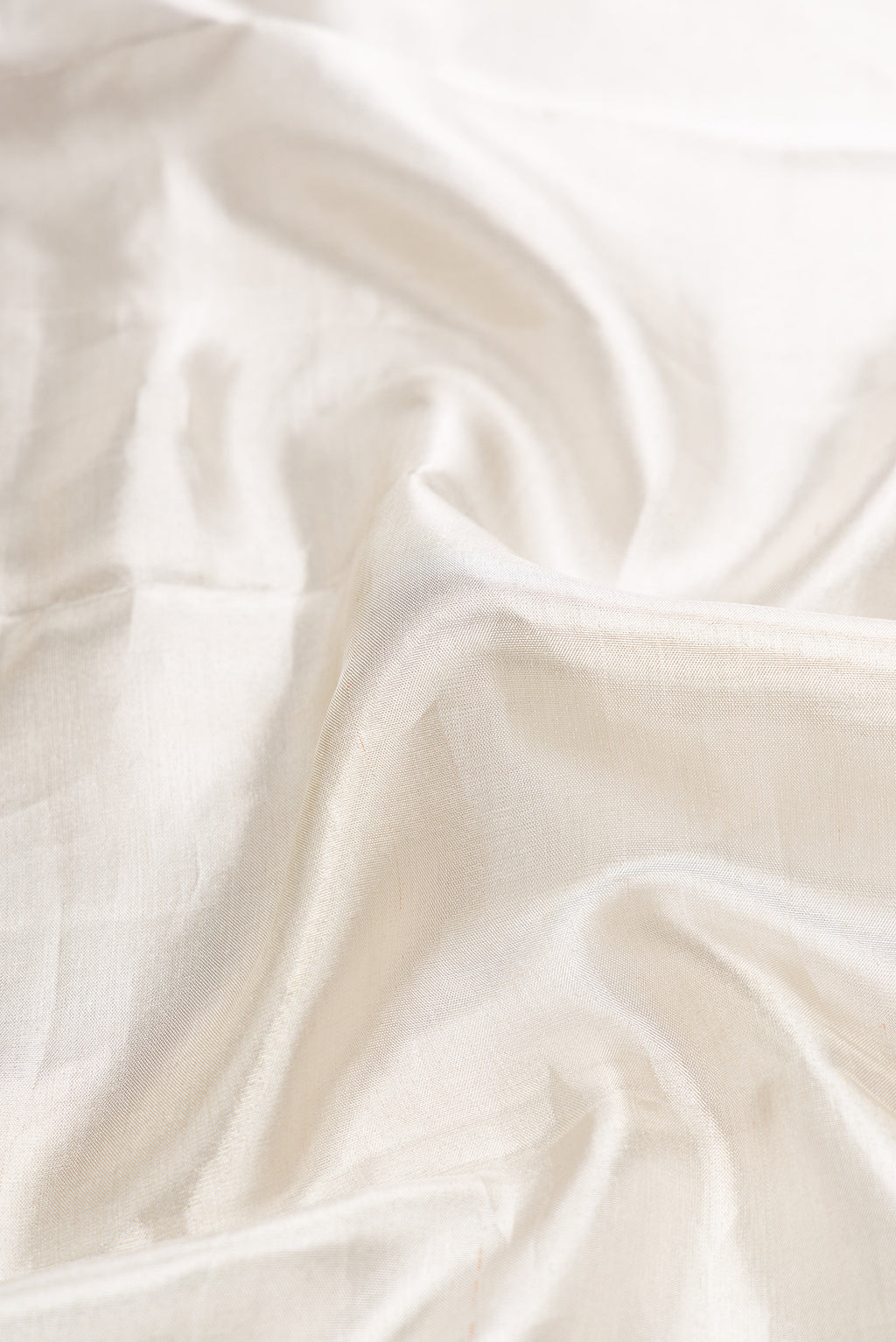 Close up of Off White Dual Tone Kanchipuram Tissue Silk Saree with Plain Body and Zari Border.  displaying folds