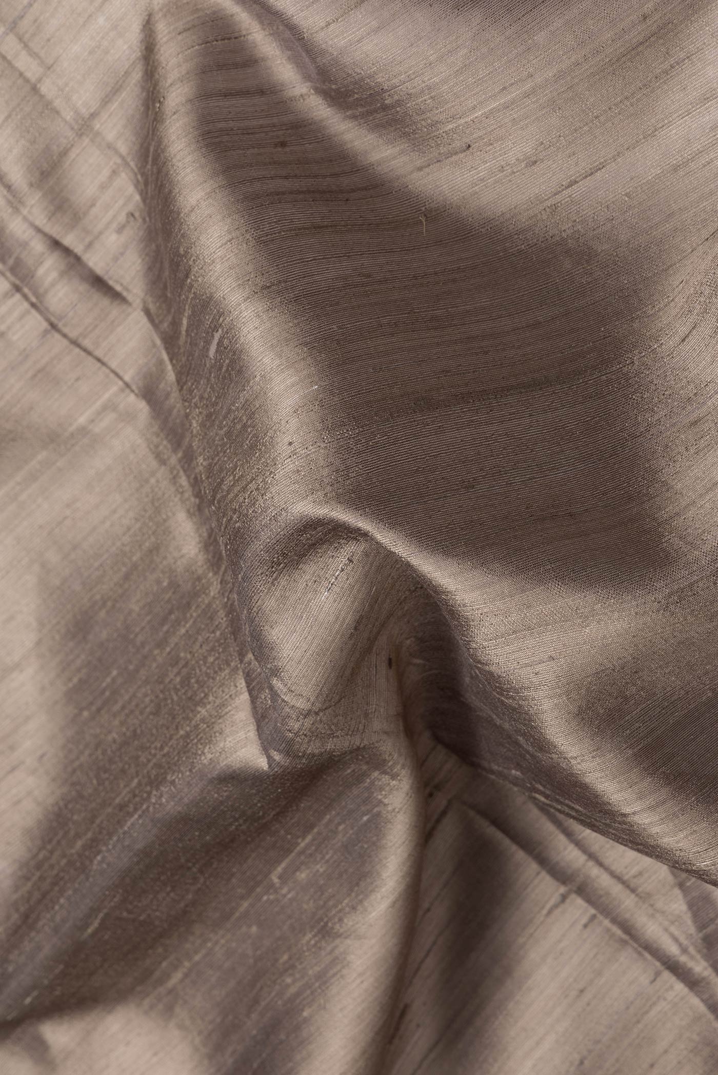 Close up of Grey Dual Tone Raw Silk Saree with Plain Body and Thin Zari Line.  displaying folds