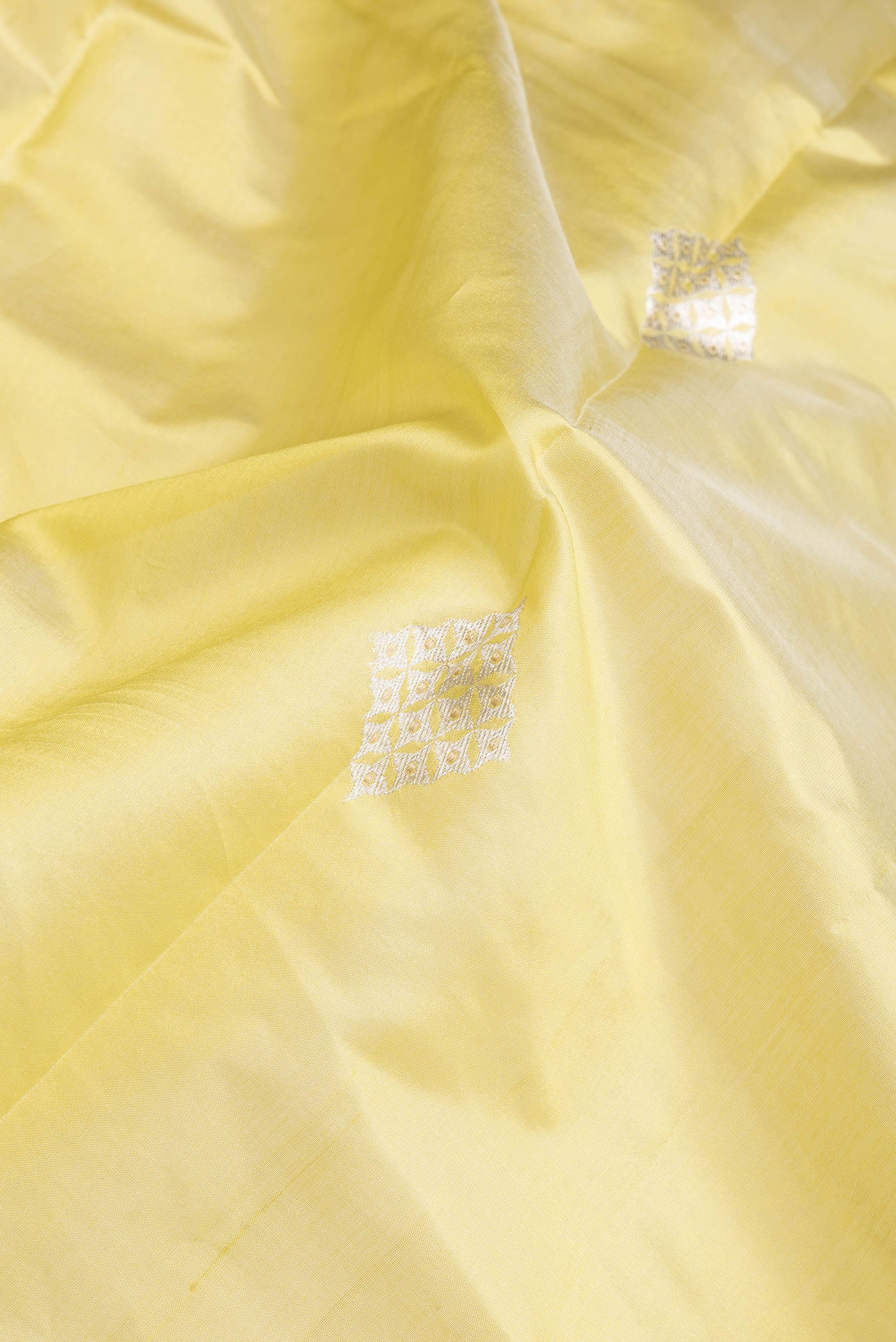 Close up of Parrot Green Dual Tone Tussar Silk Saree with Zari Butta on the body and Zari Border.  displaying folds