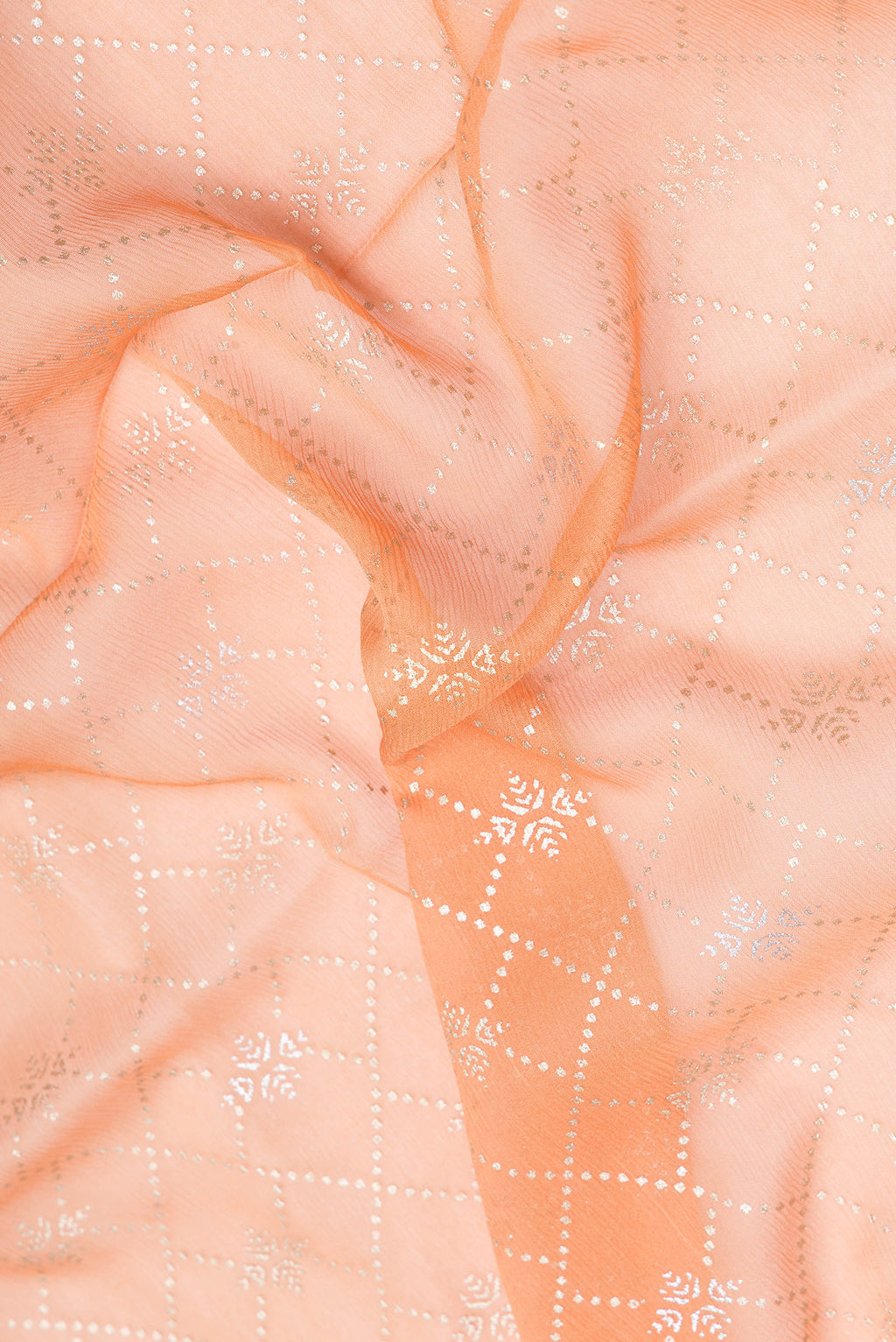 Close up of Peach Mysore Chiffon Saree with Printed design on the body and Zari Border.  displaying folds