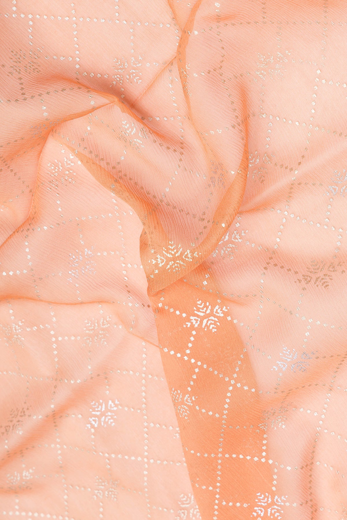 Close up of Peach Mysore Chiffon Saree with Printed design on the body and Zari Border.  displaying folds