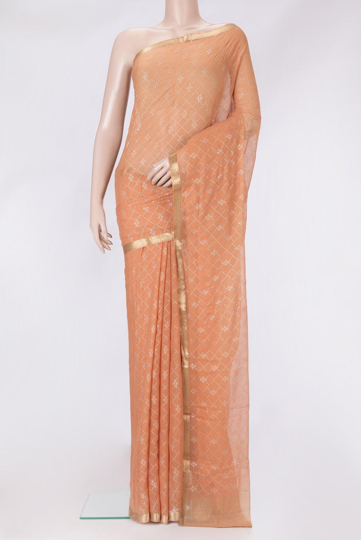 Peach Mysore Chiffon Saree with Printed design on the body and Zari Border.  displayed on a mannequin