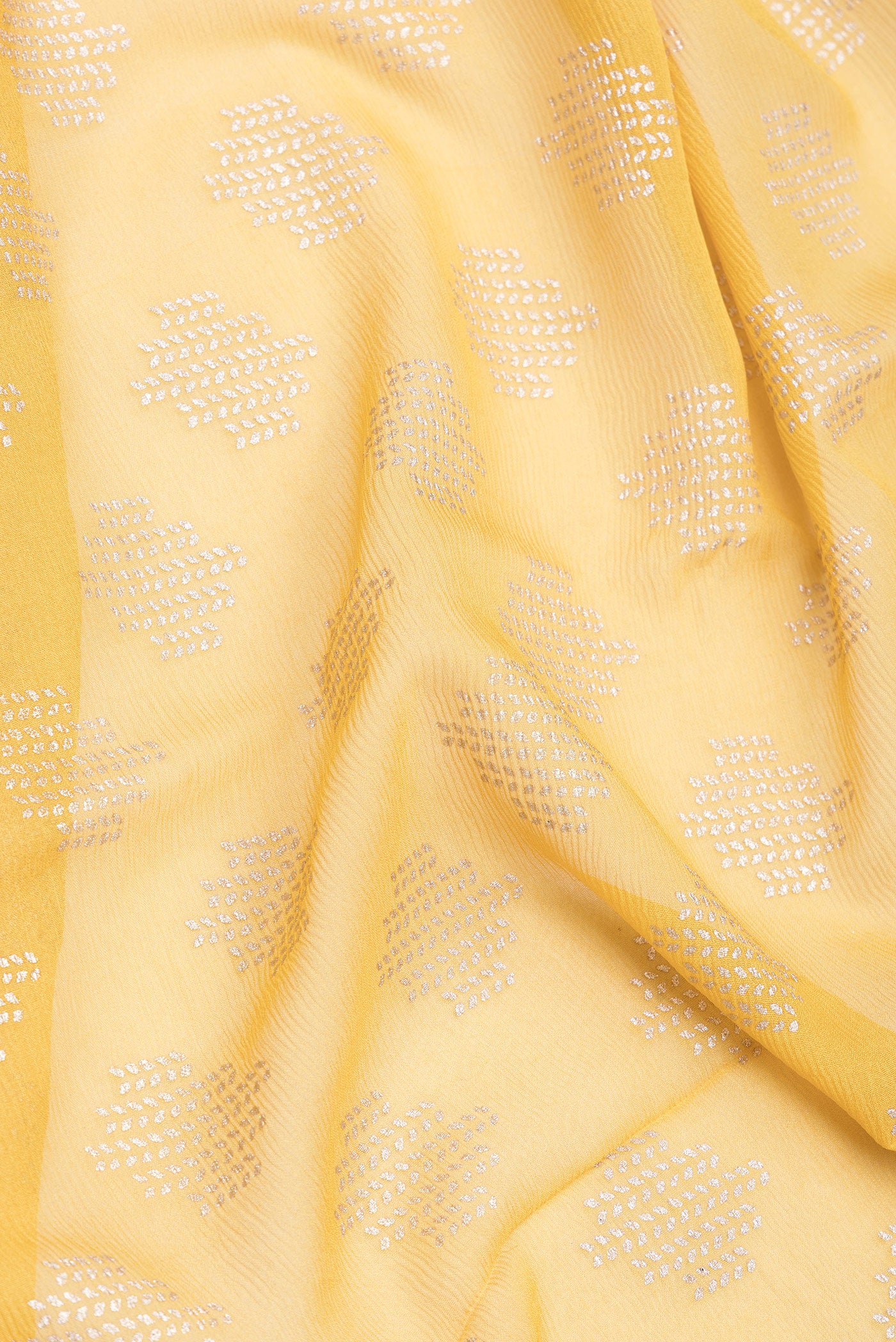 Close up of Yellow Mysore Chiffon Saree with Printed design on the body and Zari Border.  displaying folds