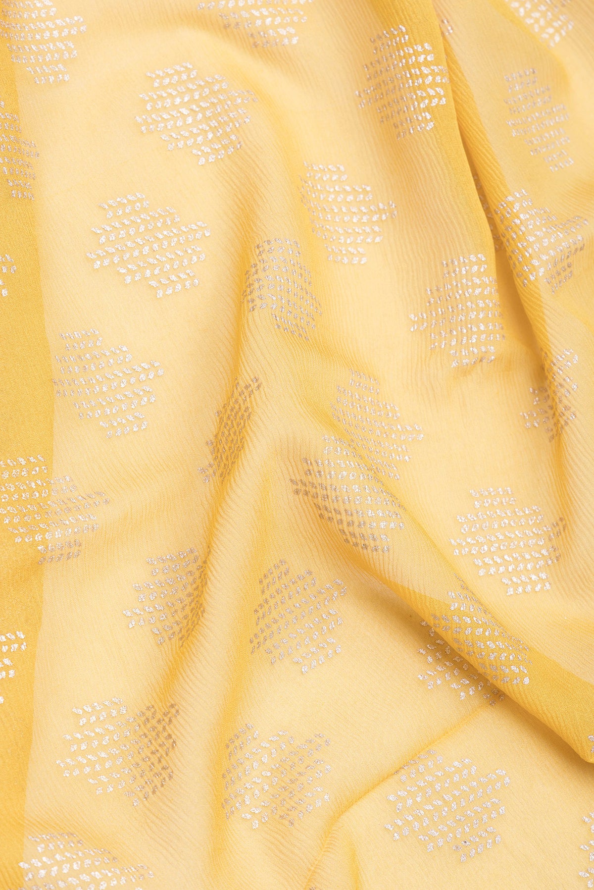 Close up of Yellow Mysore Chiffon Saree with Printed design on the body and Zari Border.  displaying folds