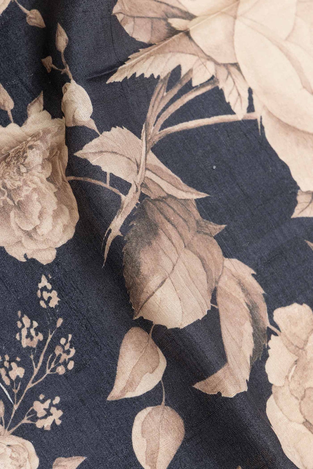 Close up of Black Dual Tone Tussar Silk SareePrinted design on the body and Zari Border displaying folds