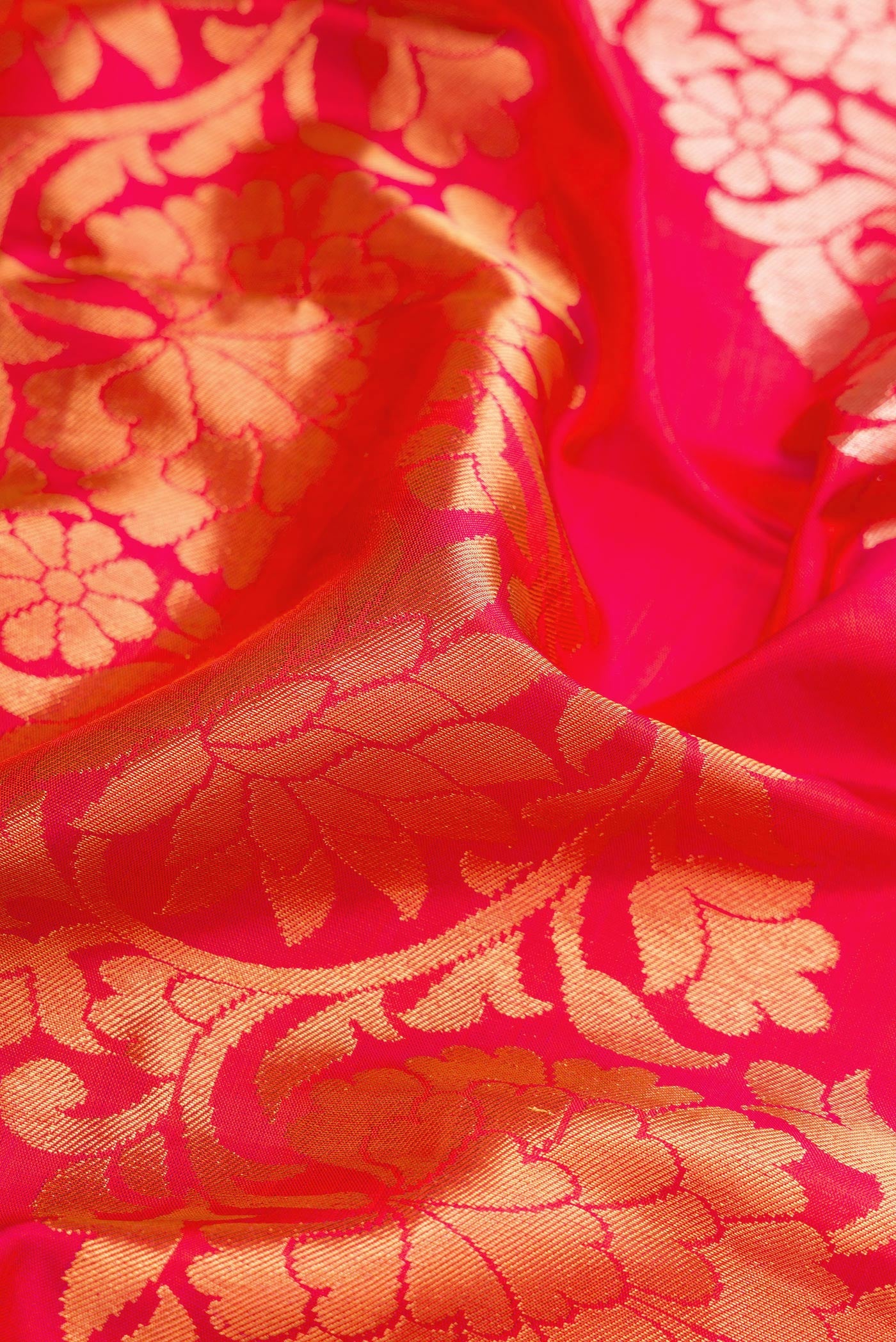 Close up of Coral Dual Tone Kanchipuram Silk Saree with Zari Brocade on the body and Zari Border.  displaying folds