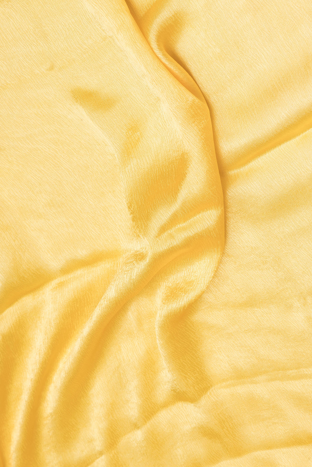 Close up of Yellow Satin Crepe Saree with Plain Body and Embroidery Border.  displaying folds