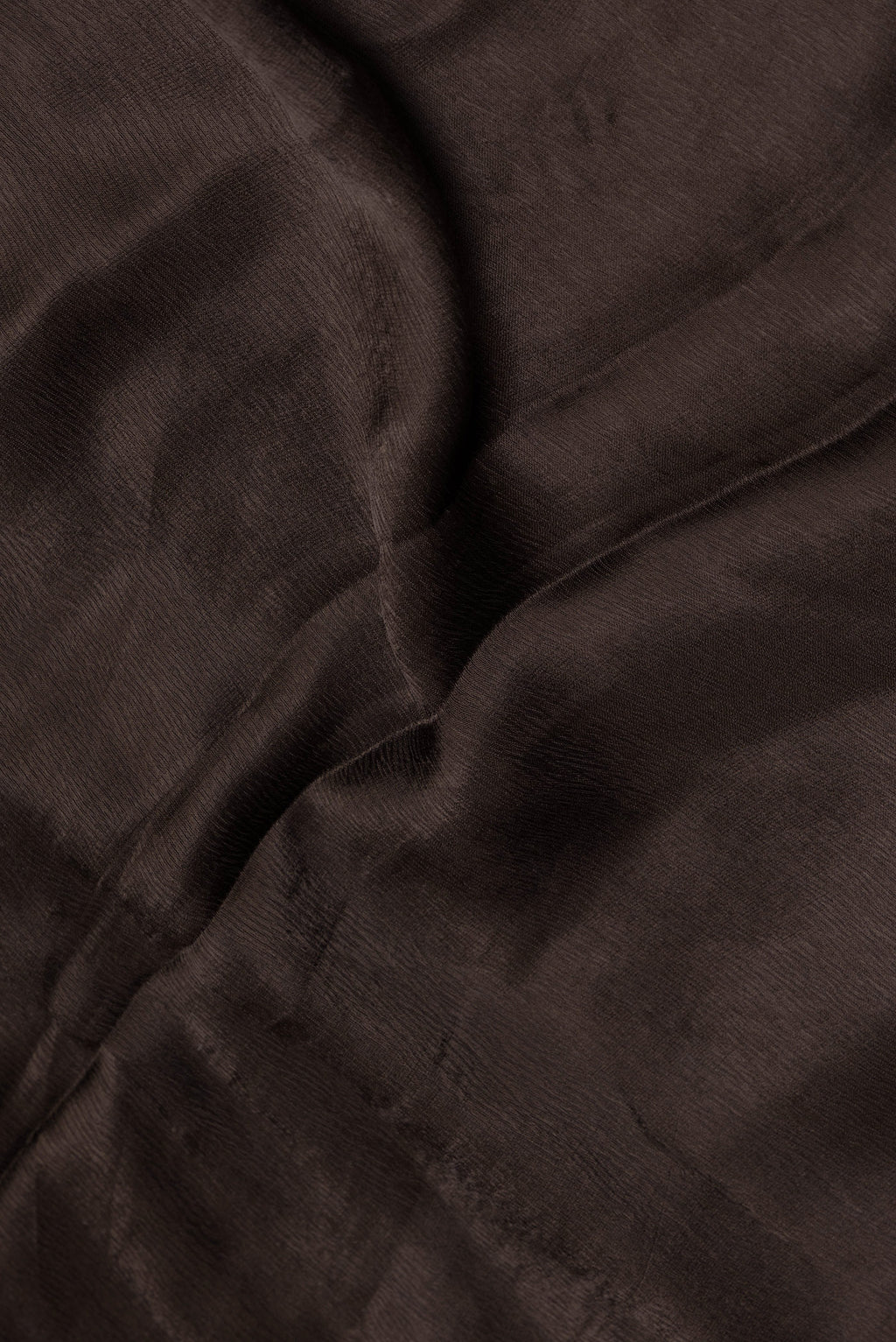 Close up of Brown Satin Crepe Saree with Plain Body and Embroidery Border.  displaying folds