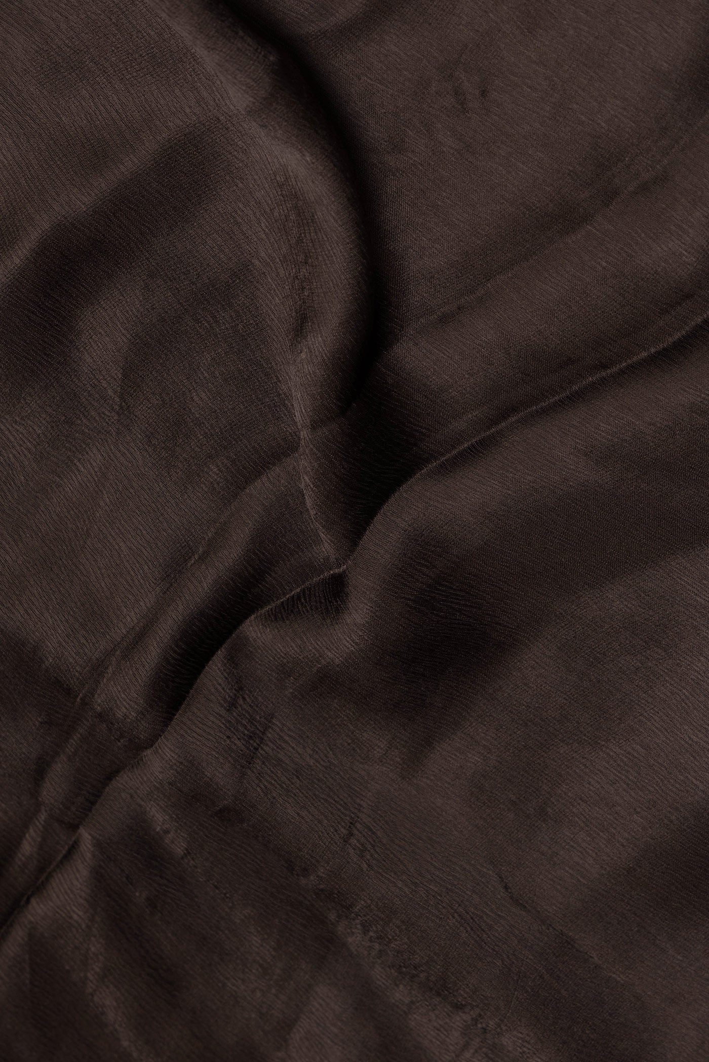 Close up of Brown Satin Crepe Saree with Plain Body and Embroidery Border.  displaying folds