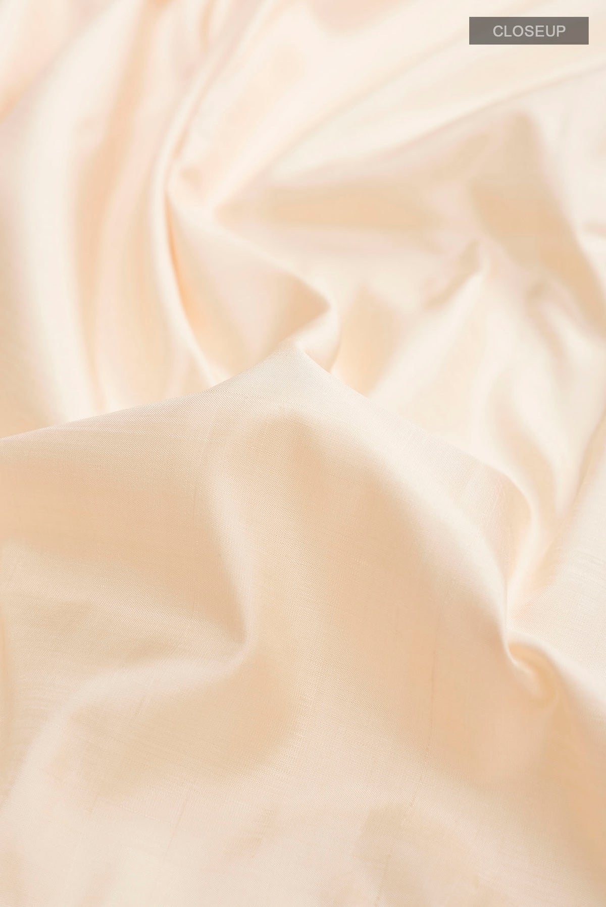 Close up of Cream Kanchipuram Silk Saree with Plain Body and Temple Border displaying folds