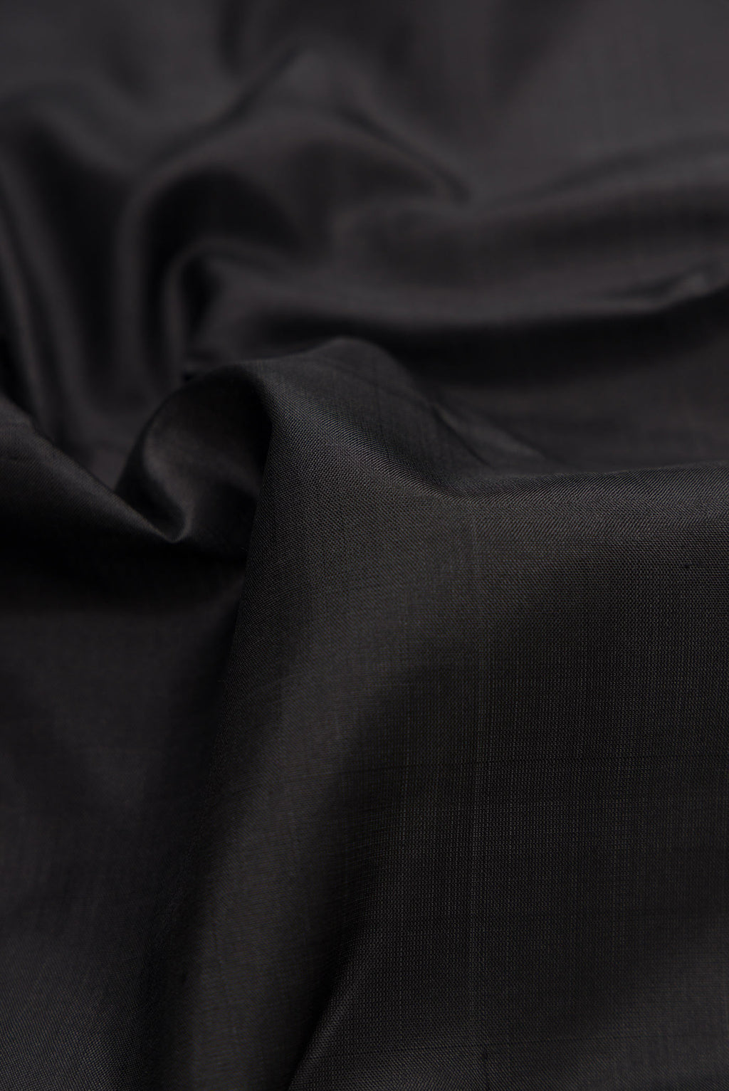 Close up of Black Dual Tone Kanjivaram Silk Saree with Plain Body and Zari Border.  displaying folds