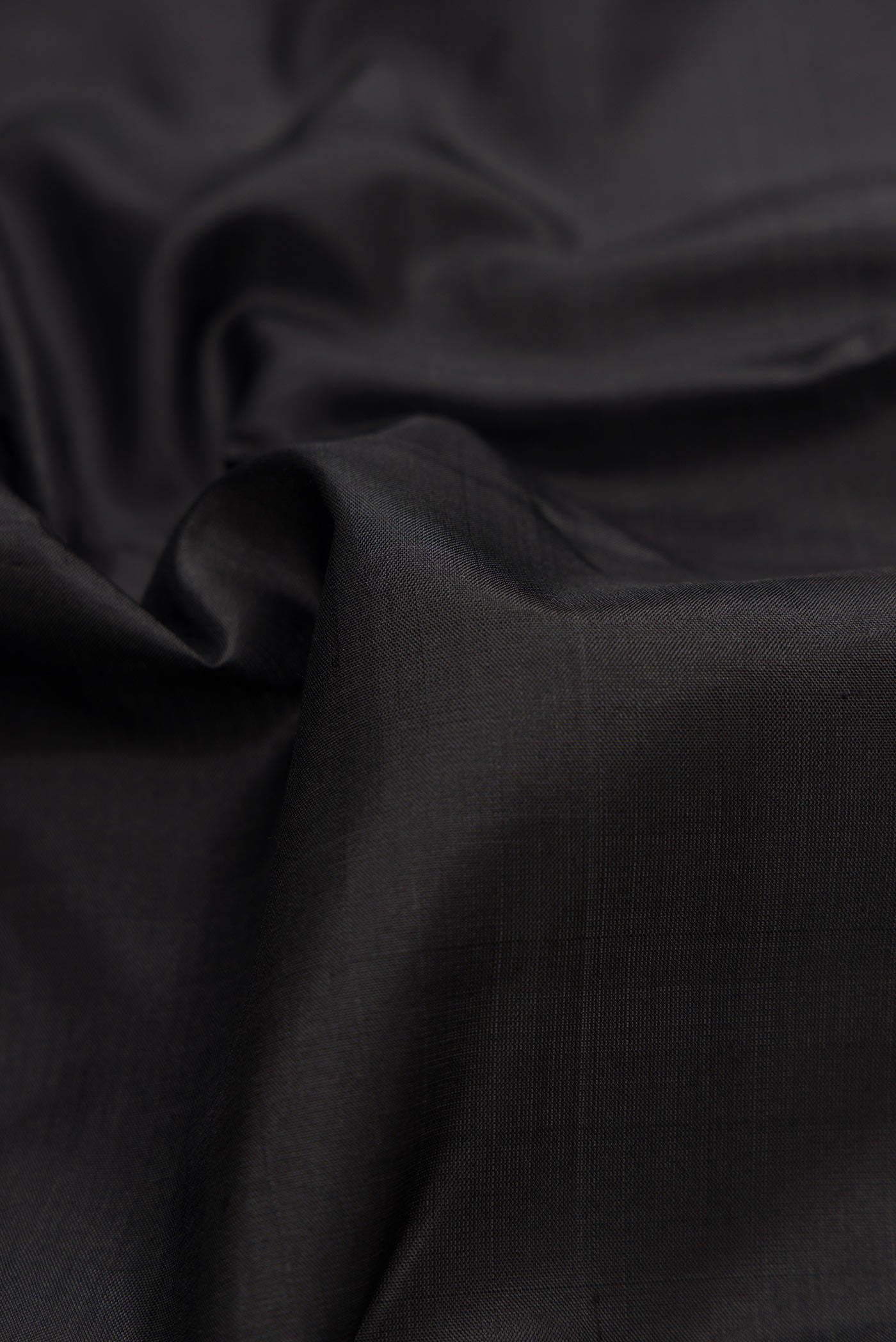 Close up of Black Dual Tone Kanjivaram Silk Saree with Plain Body and Zari Border.  displaying folds