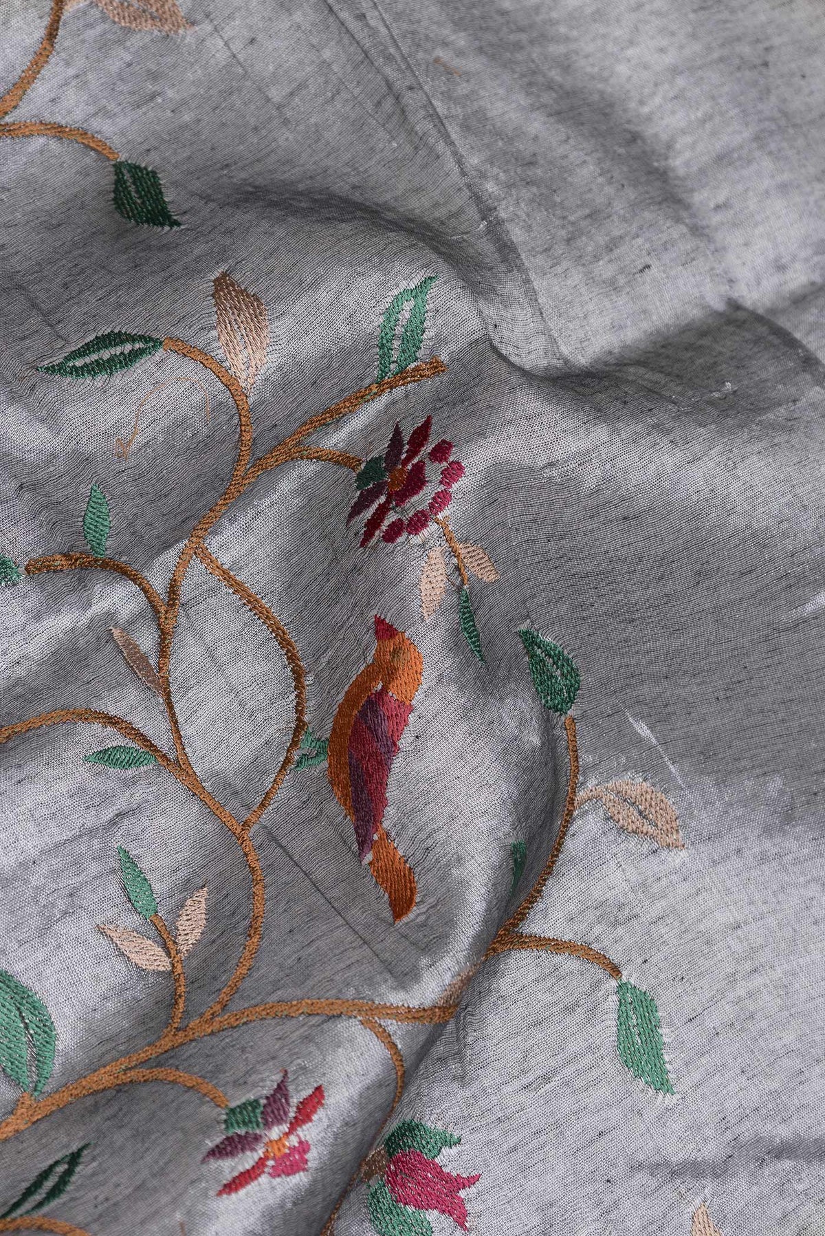 Close up of Grey Dual Tone Organza Silk Saree with Embroidery on the body and Zari Border.  displaying folds