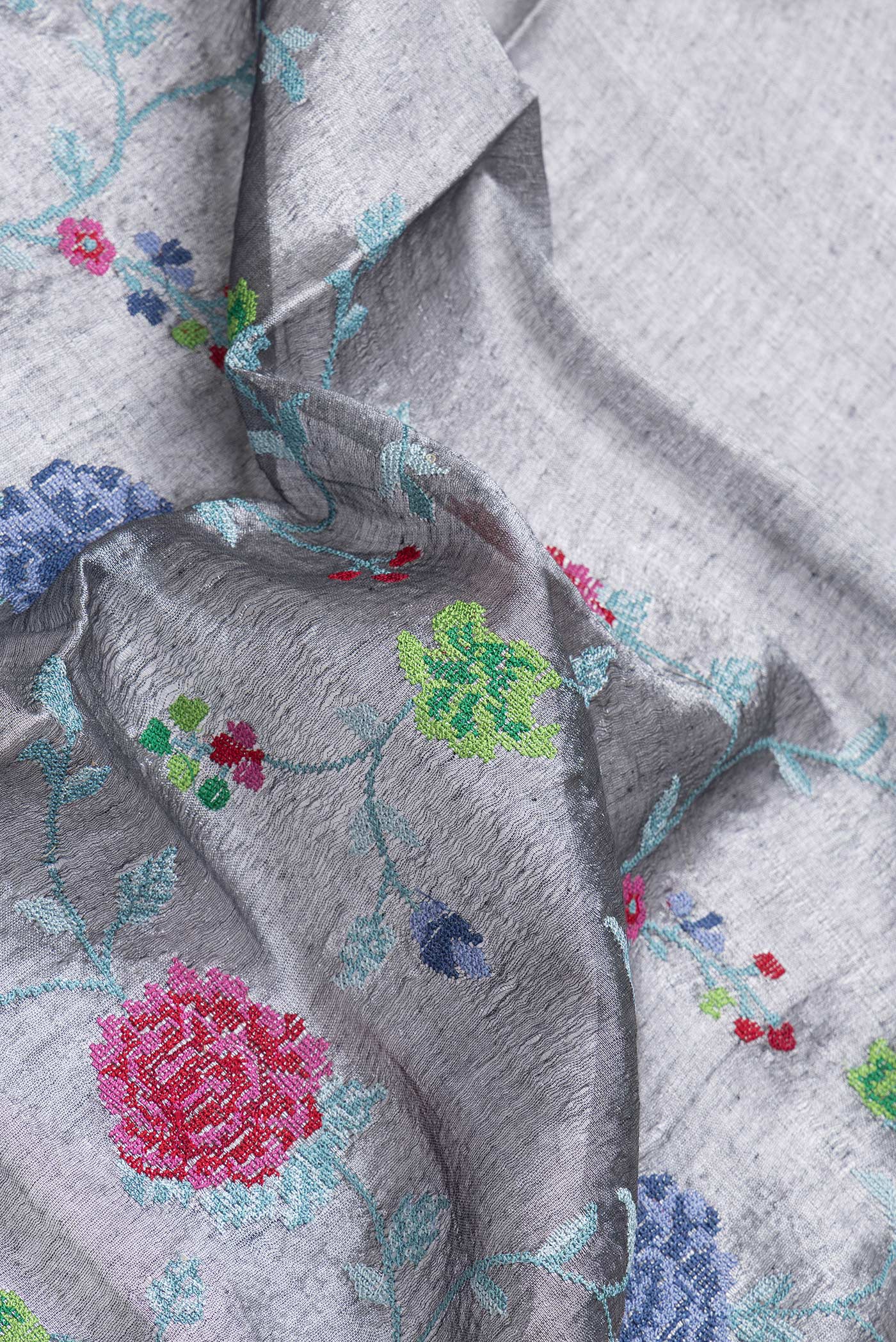 Close up of Grey Dual Tone Organza Silk Saree with Embroidery on the body and Paithani Border.  displaying folds