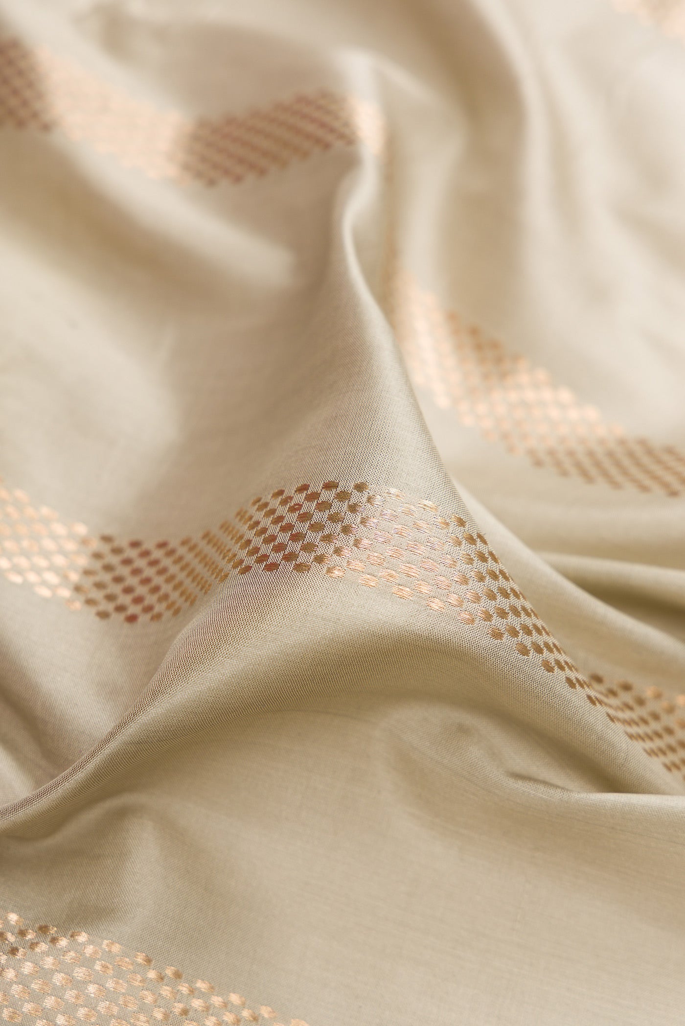 Close up of Beige Banarasi Silk Saree with Stripes on the body and Zari Border.  displaying folds