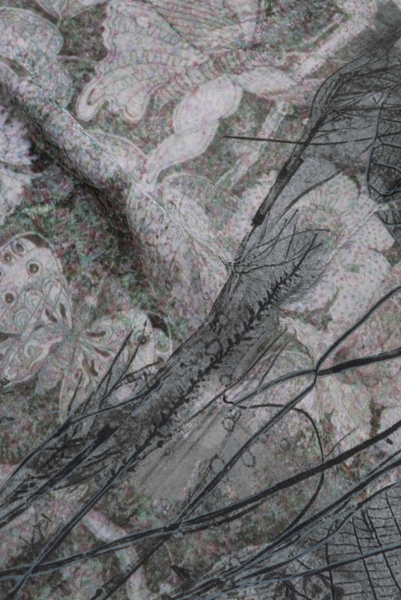 Close up of Grey Crepe Saree with Printed design on the body and Zari Border.  displaying folds