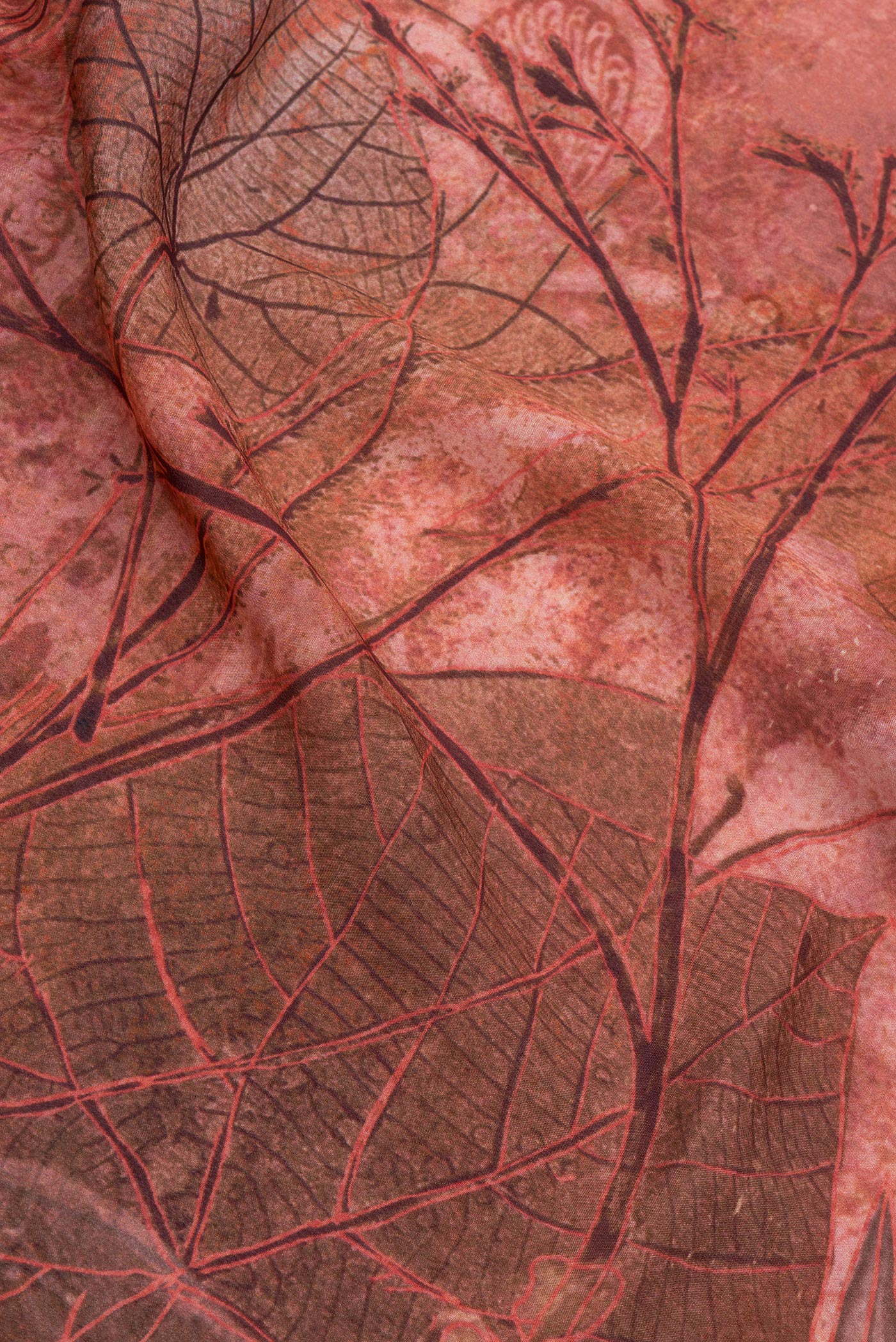 Close up of Peach Crepe Saree with Printed design on the body and Zari Border.  displaying folds