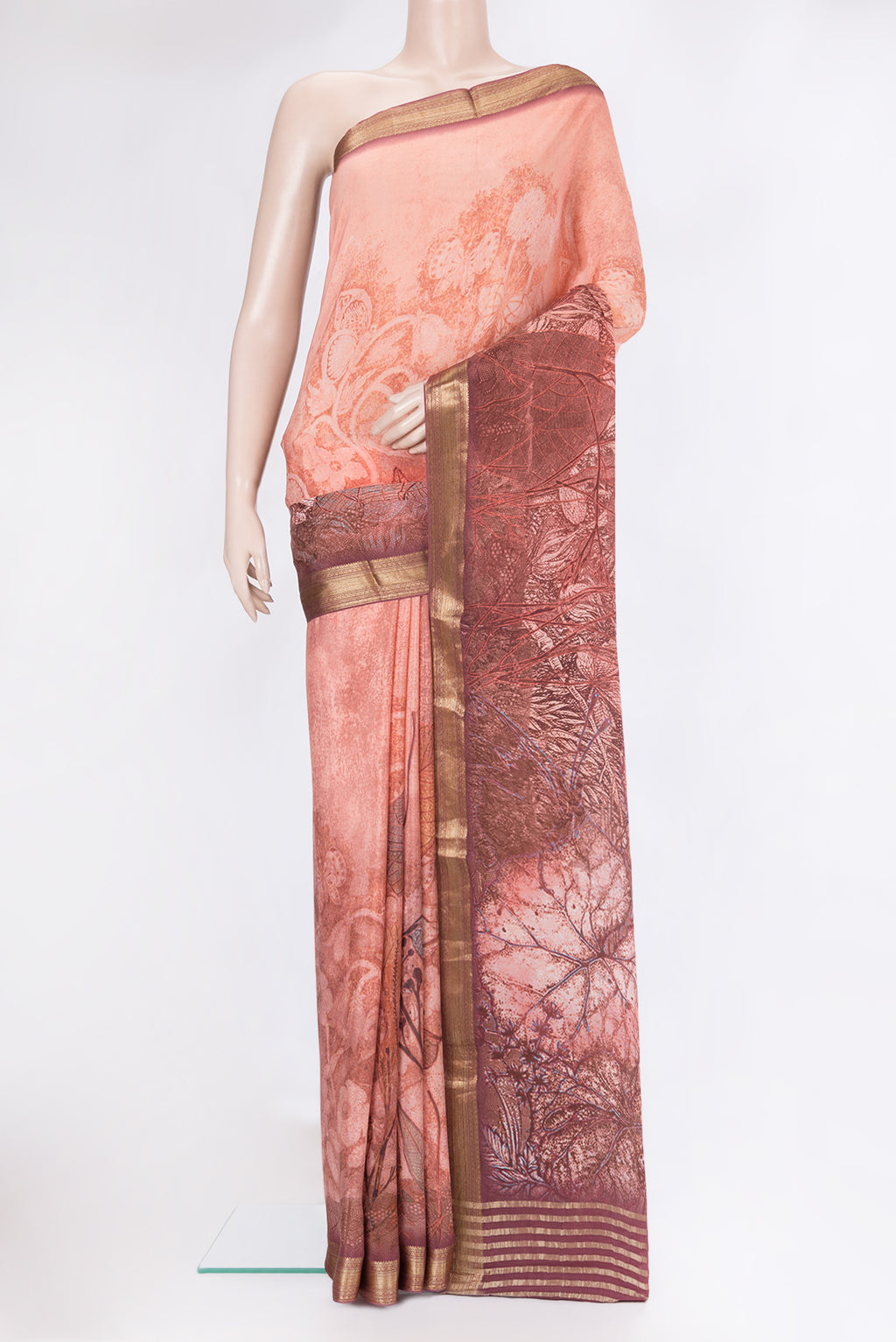 Peach Crepe Saree with Printed design on the body and Zari Border.  displayed on a mannequin