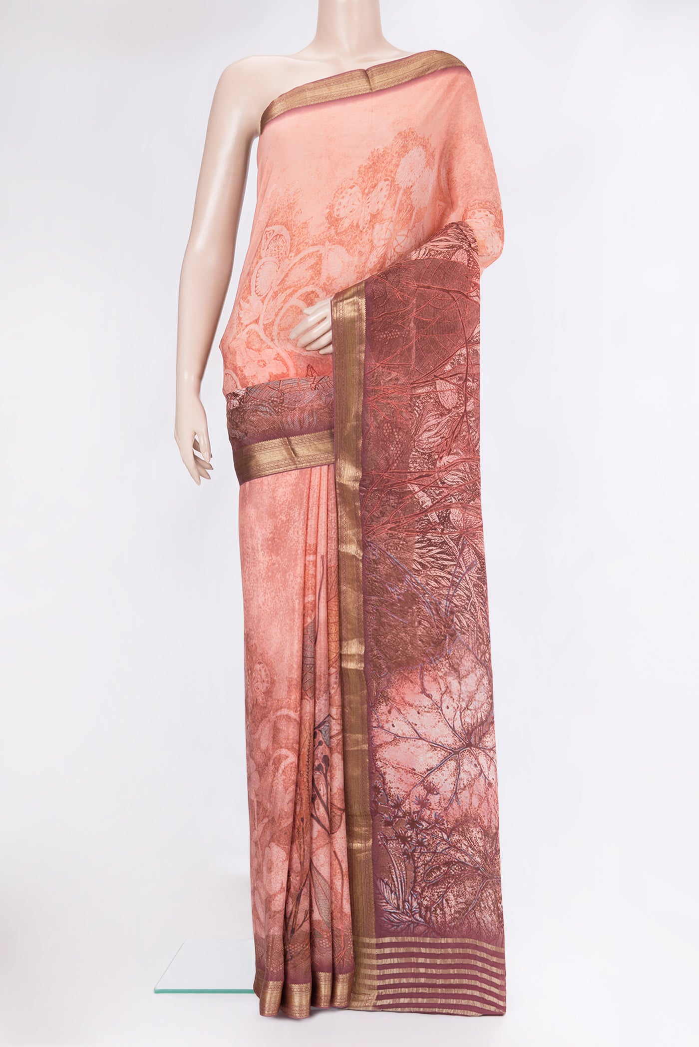 Peach Crepe Saree with Printed design on the body and Zari Border.  displayed on a mannequin