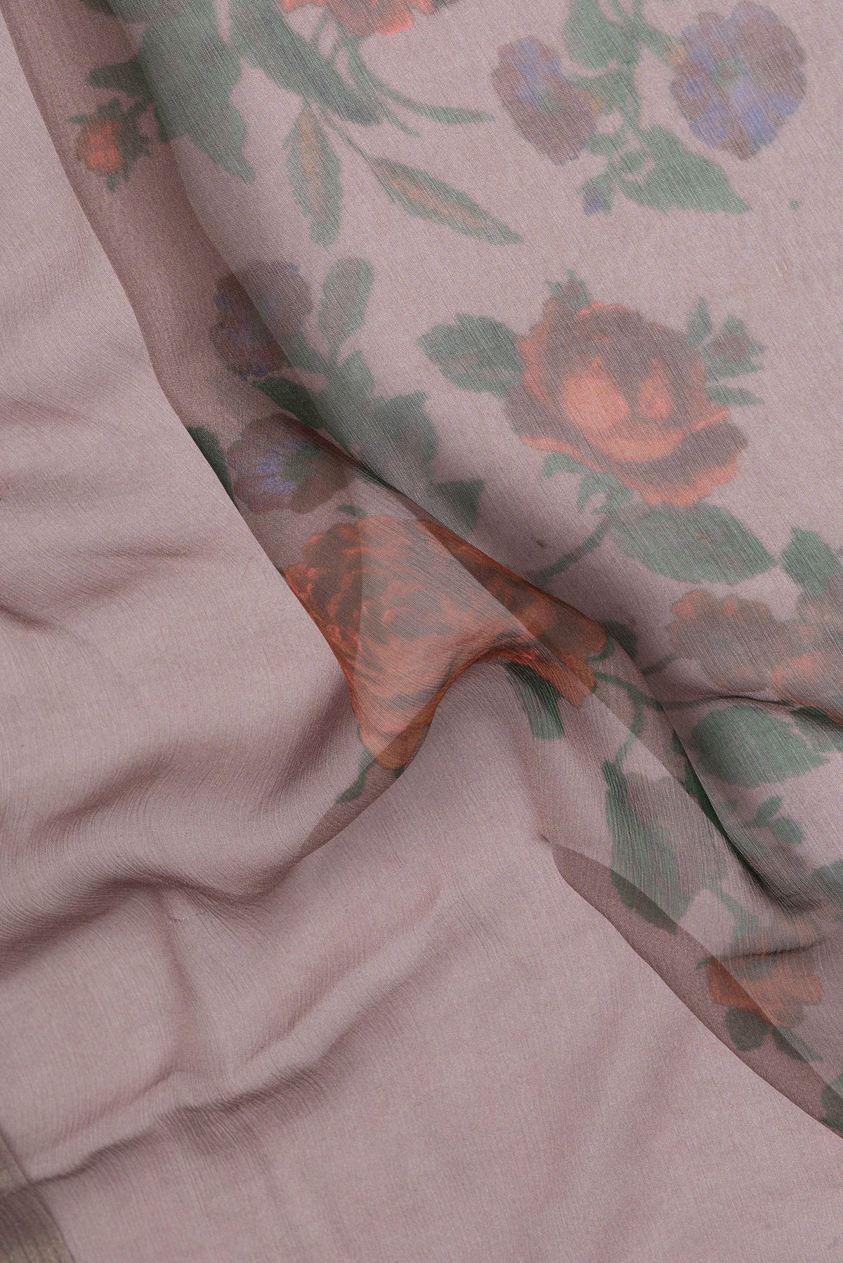 Close up of Brown Chiffon Saree with Printed design on the body and Zari Border.  displaying folds
