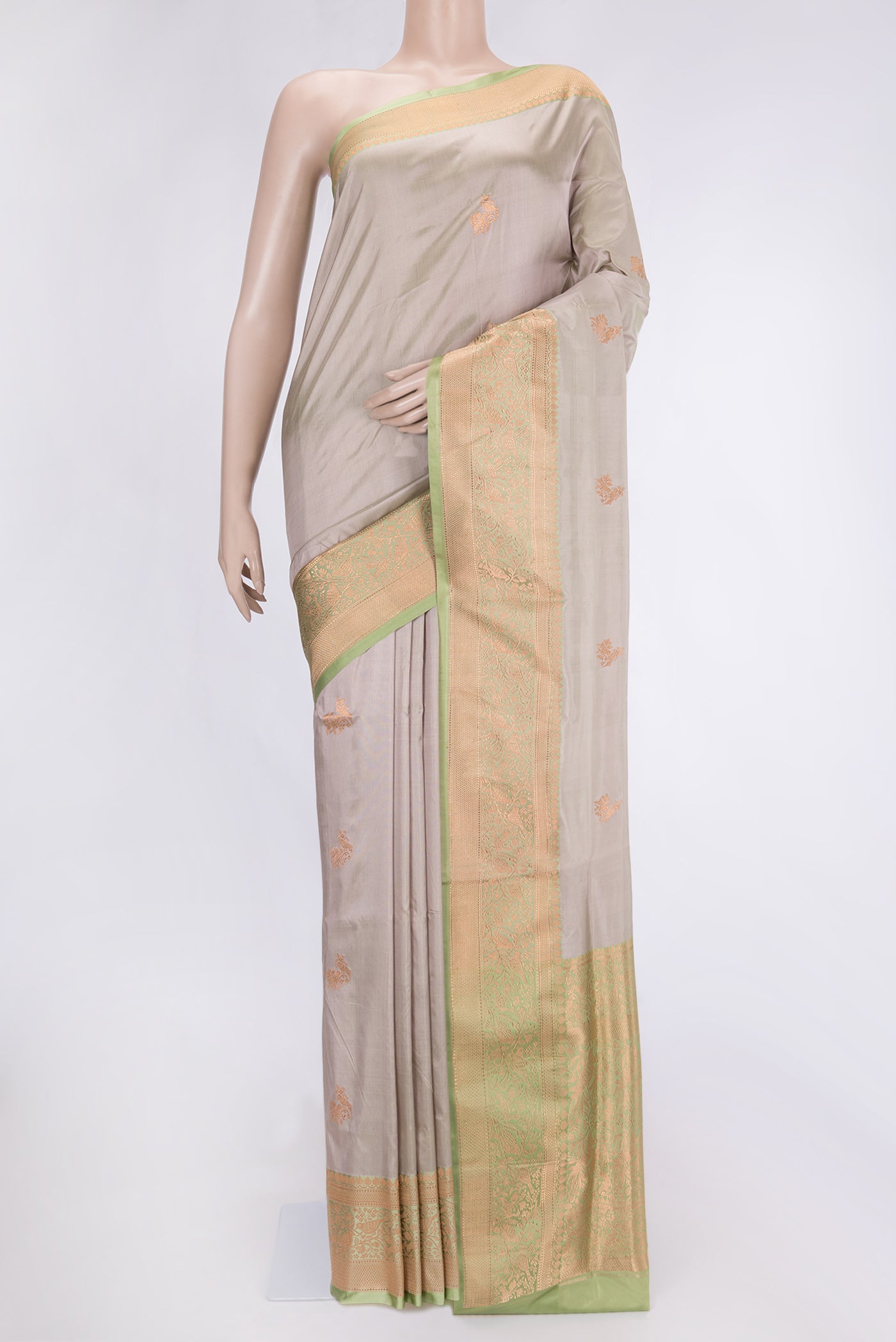 Beige Dual Tone Banarasi Silk Saree with Zari Butta on the body and Zari Border.  displayed on a mannequin