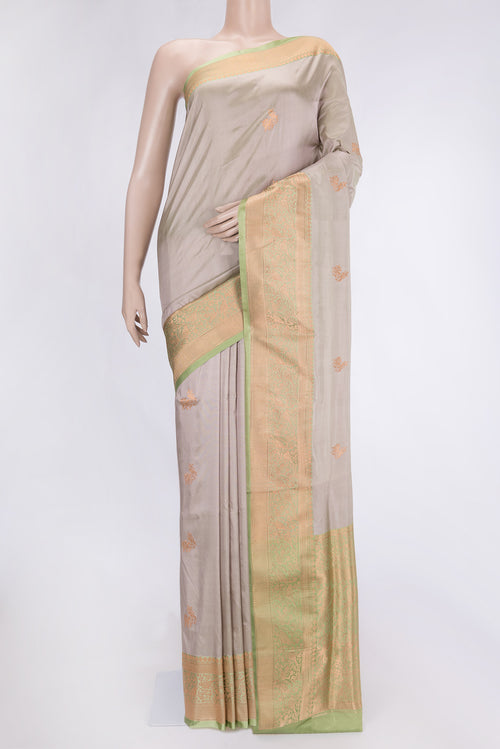 Beige Dual Tone Banarasi Silk Saree with Zari Butta on the body and Zari Border.  displayed on a mannequin