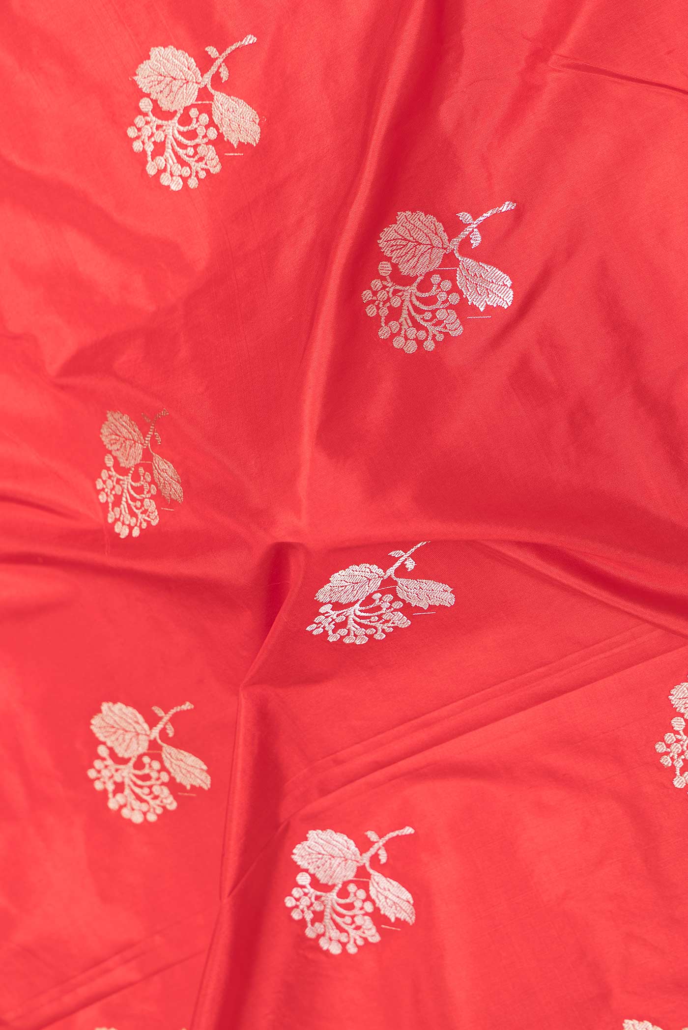 Close up of Red Dual Tone Banarasi Silk Saree with Zari Butta on the body and Plain Border displaying folds