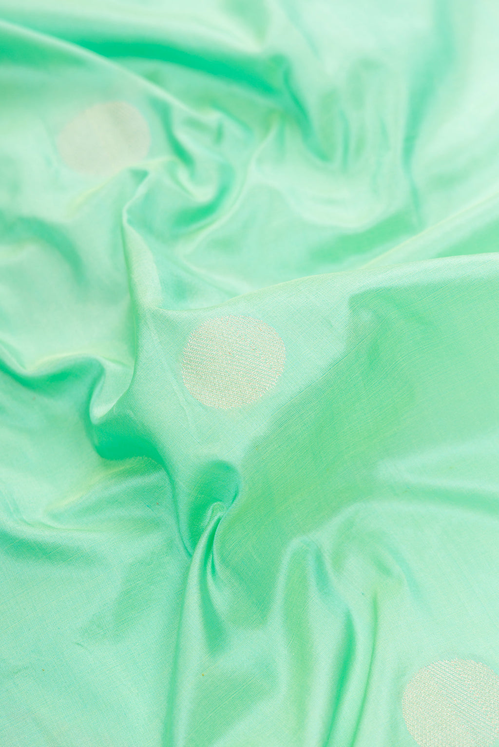 Close up of Sea Green Dual Tone Banarasi Silk Saree with Zari Butta on the body and Zari Border.  displaying folds
