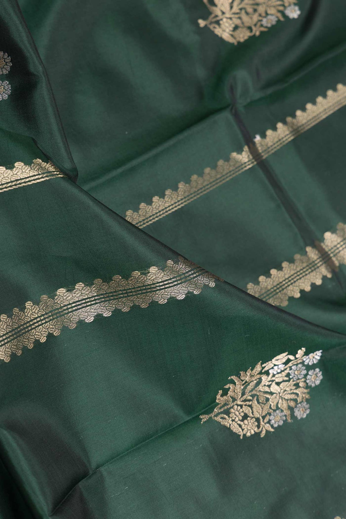 Close up of Bottle Green Dual Tone Banarasi Silk Saree with Zari Butta on the body and Zari Border displaying folds