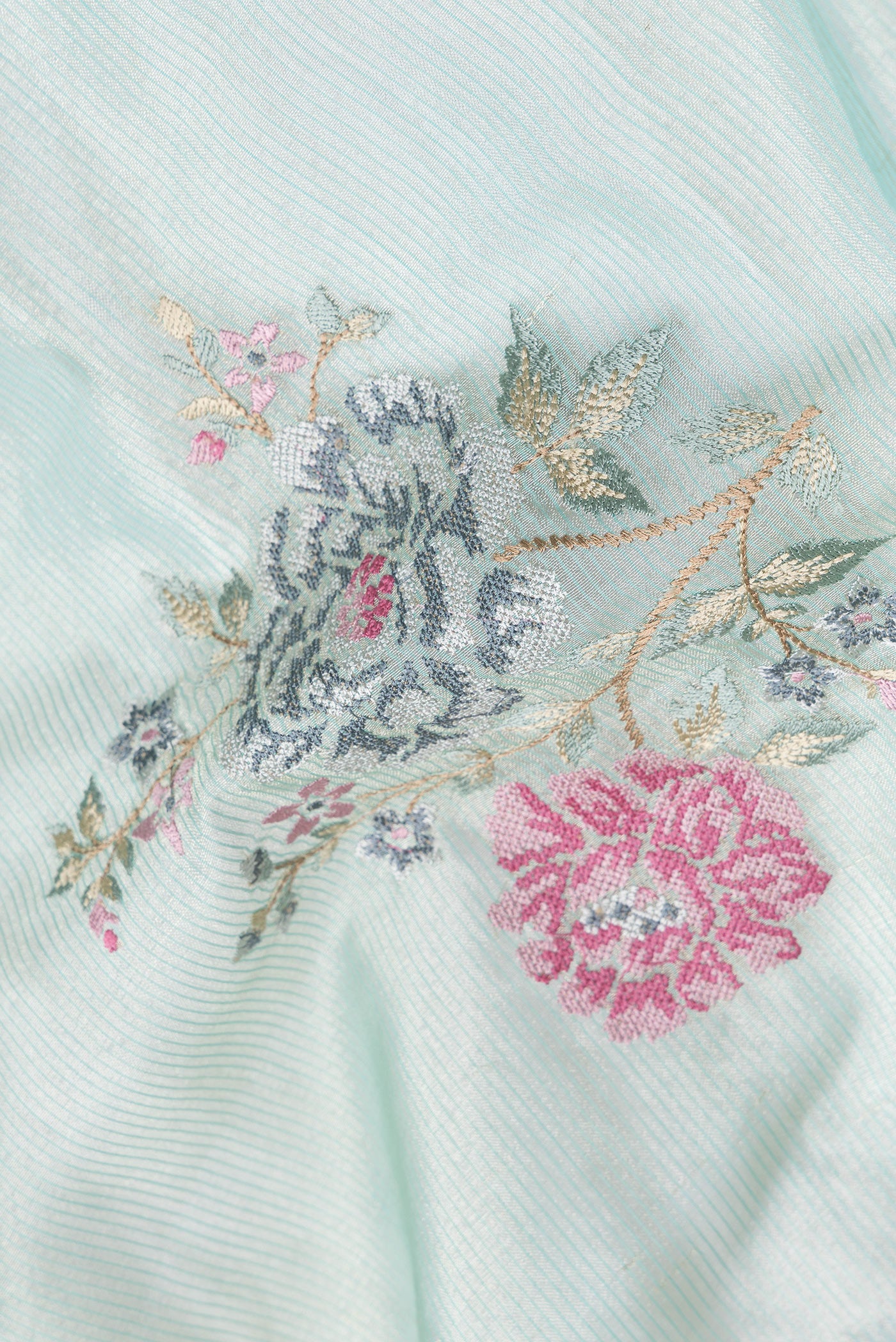 Close up of Sea Green Dual Tone Organza Silk Saree with Embroidery on the body and Zari And Thread Border.  displaying folds