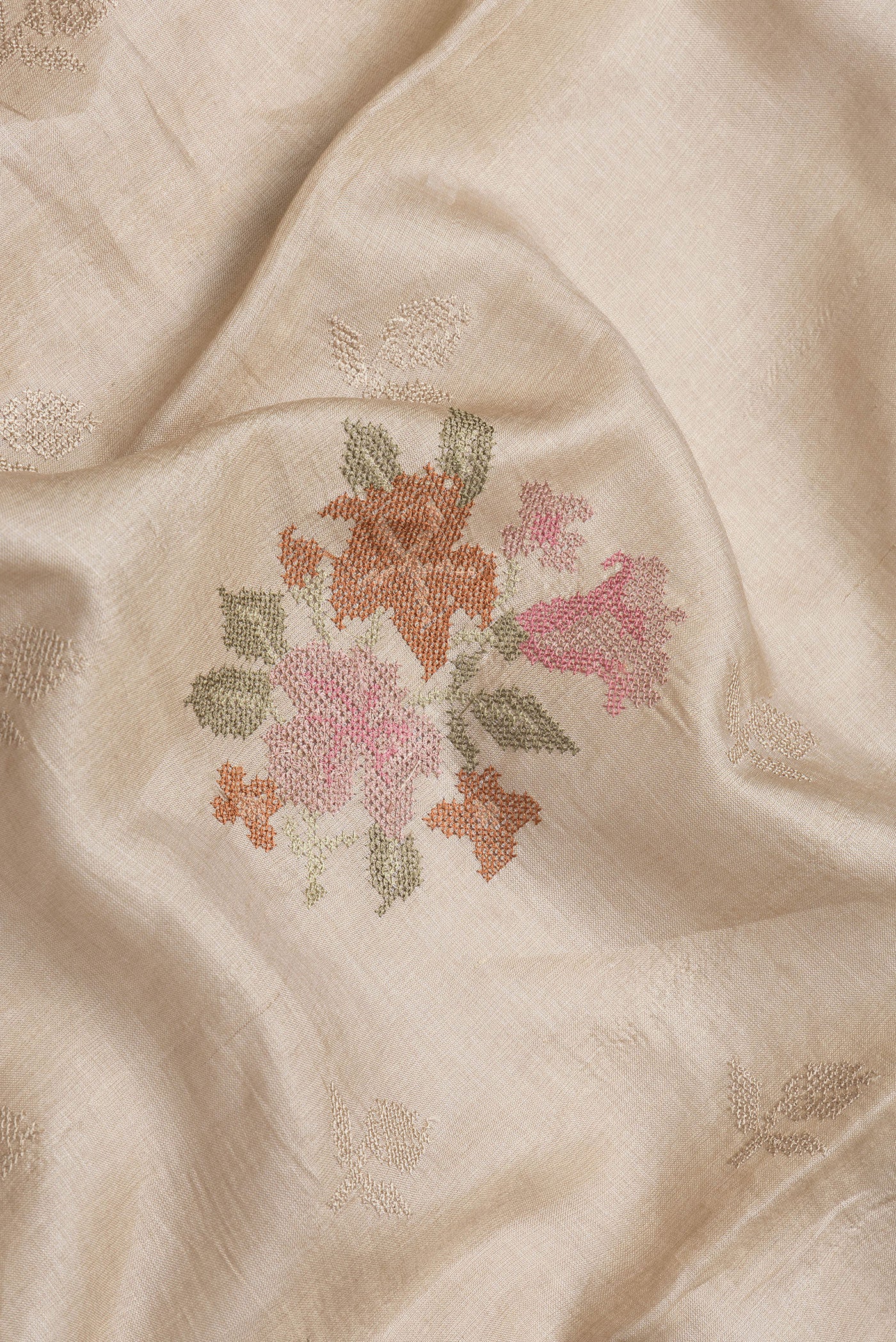 Close up of Beige Dual Tone Tussar Silk Saree with Embroidery on the body and Zari Border.  displaying folds