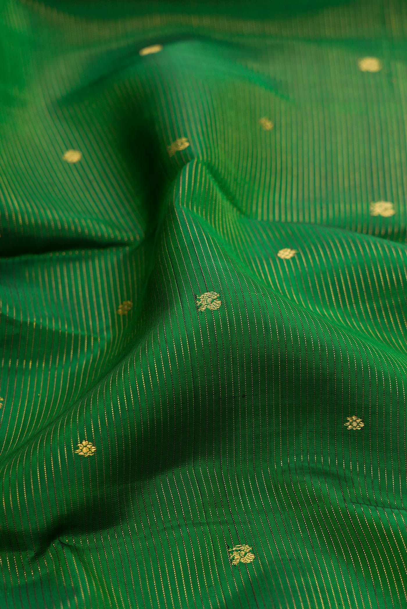 Close up of Green Dual Tone Kanjivaram Silk Saree with Stripes on the body and Zari Border.  displaying folds