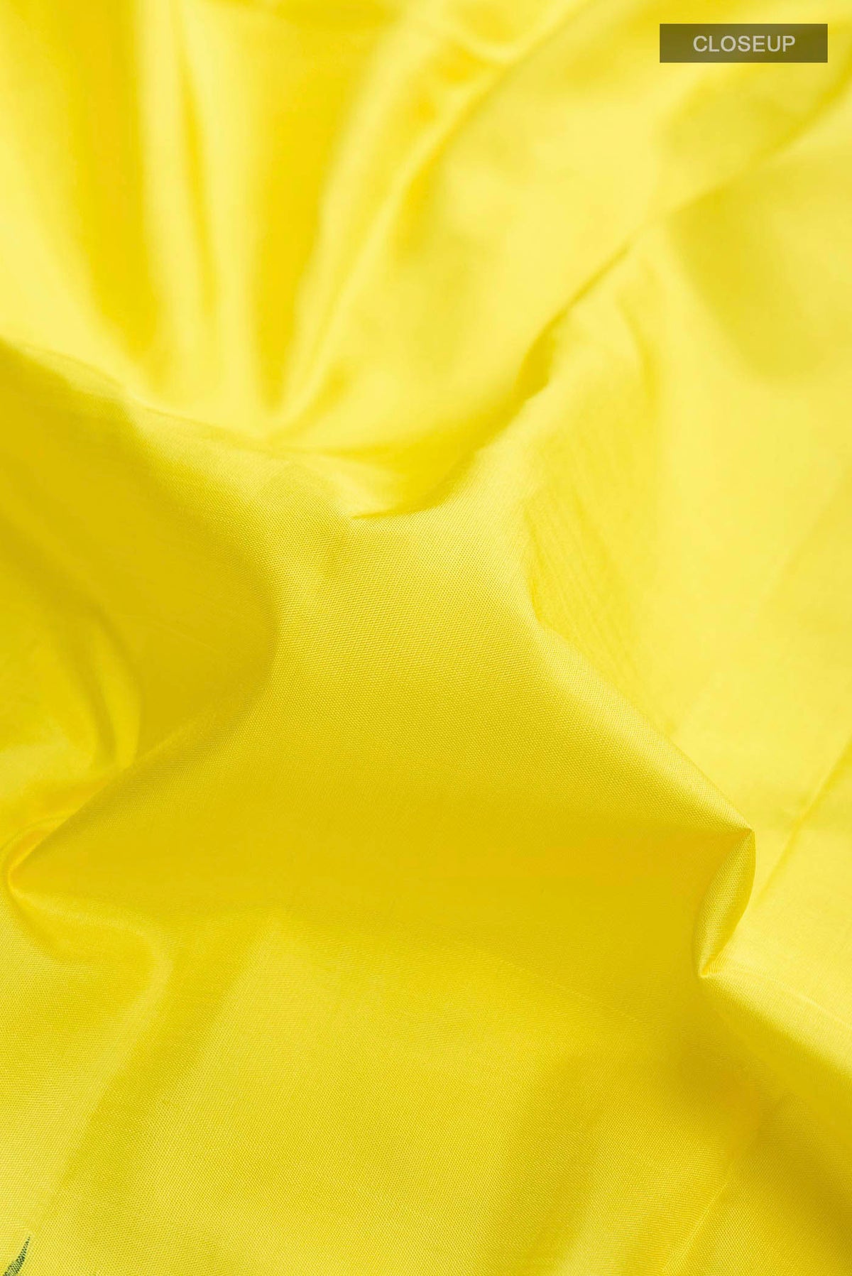 Close up of Yellow Kanchipuram Silk Saree with Plain Body and Zari Border displaying folds