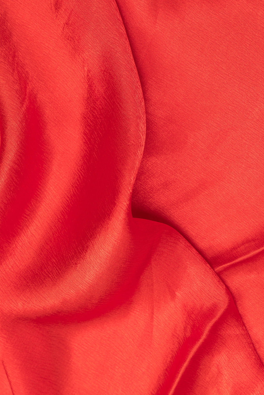 Close up of Brick Orange Crepe Saree with Plain Body and Sequin Border.  displaying folds