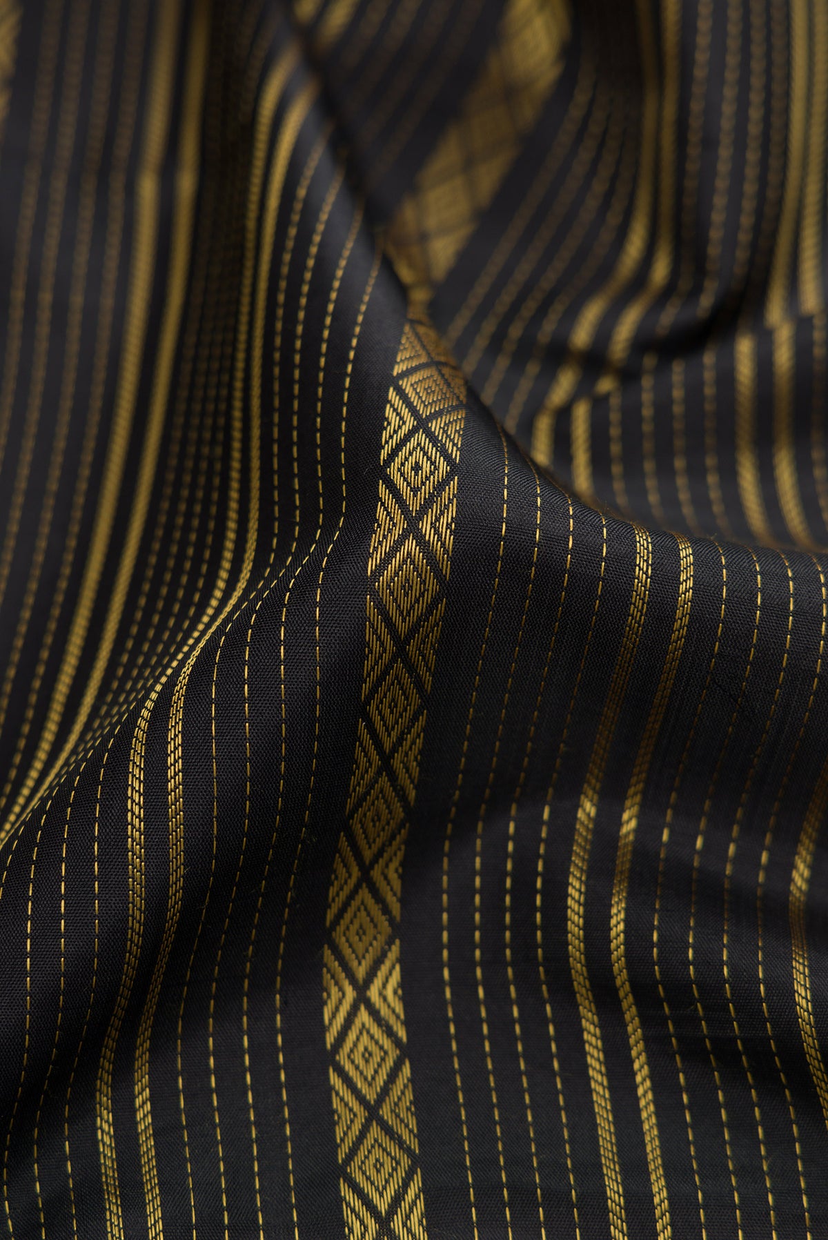 Close up of Pure Silk Pure Zari Black Dual Tone Kanjivaram Saree with Stripes on the body and Zari Border.  displaying folds