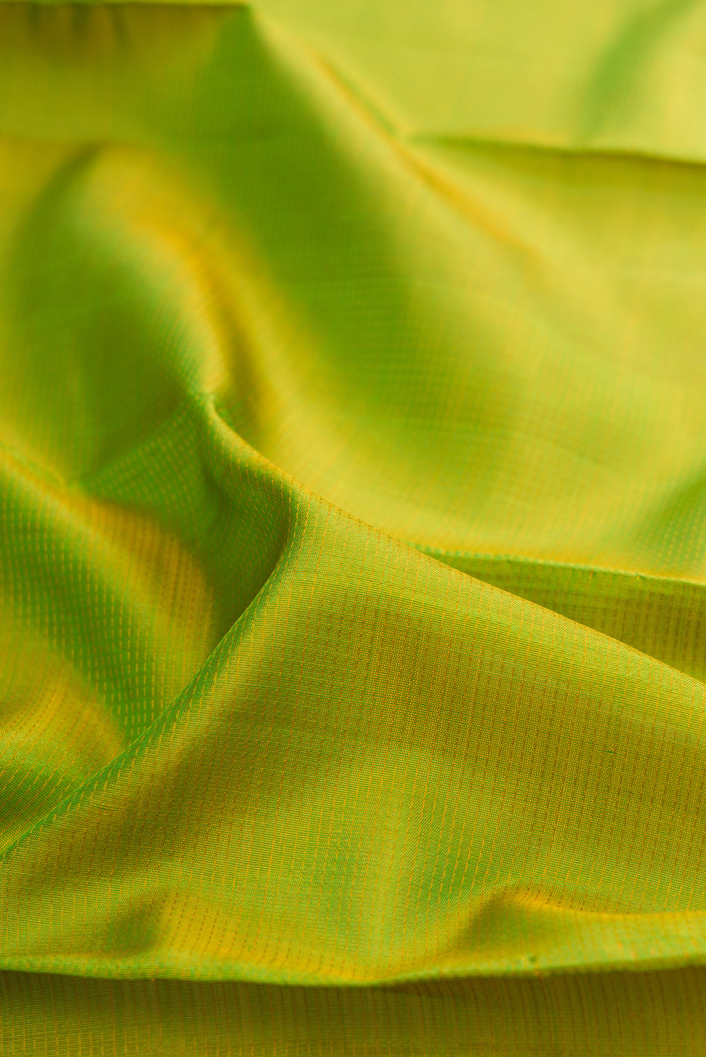 Close up of Pure Silk Pure Zari Parrot Green Kanjivaram Saree with Stripes on the body and Zari Border.  displaying folds