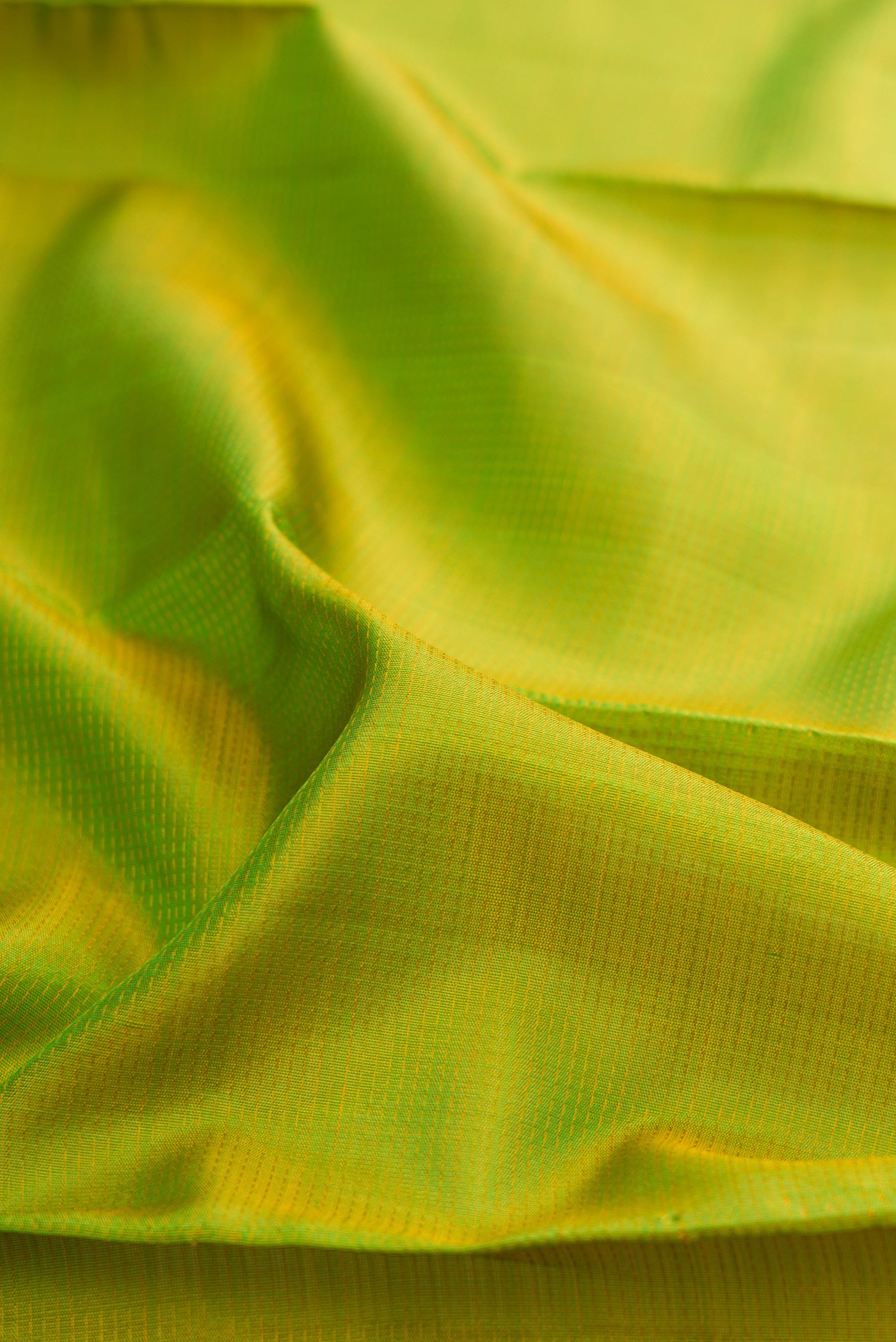Close up of Pure Silk Pure Zari Parrot Green Kanjivaram Saree with Stripes on the body and Zari Border.  displaying folds