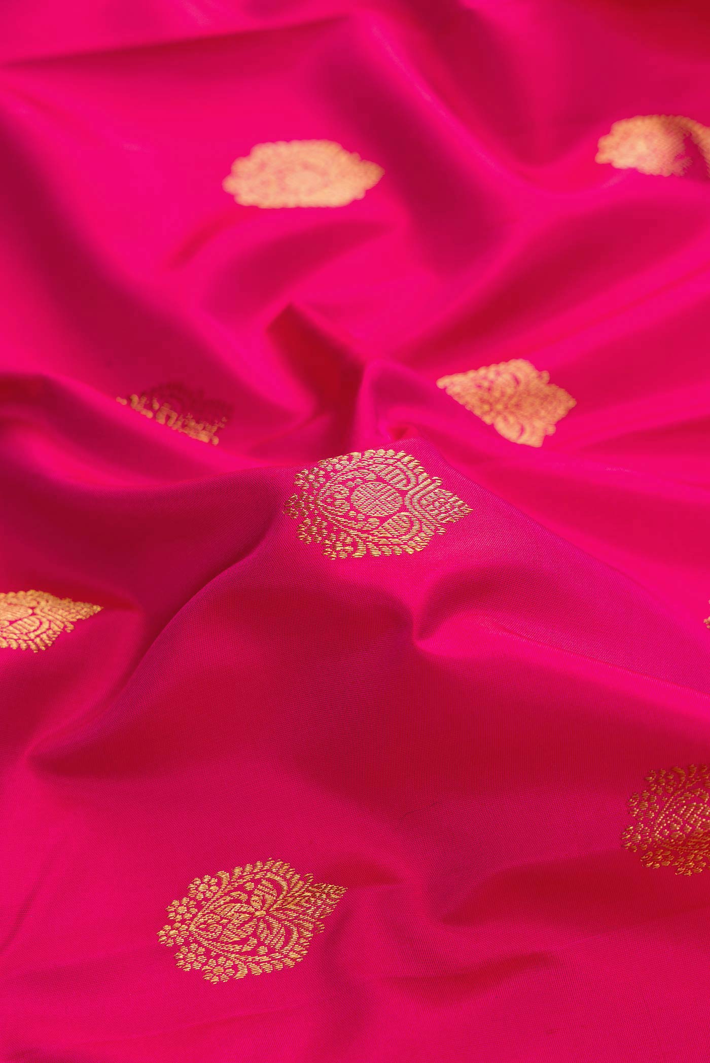 Close up of Pure Silk Pure Zari Dark Pink Dual Tone Kanchipuram Saree with Zari Butta on the body and Zari Border displaying folds