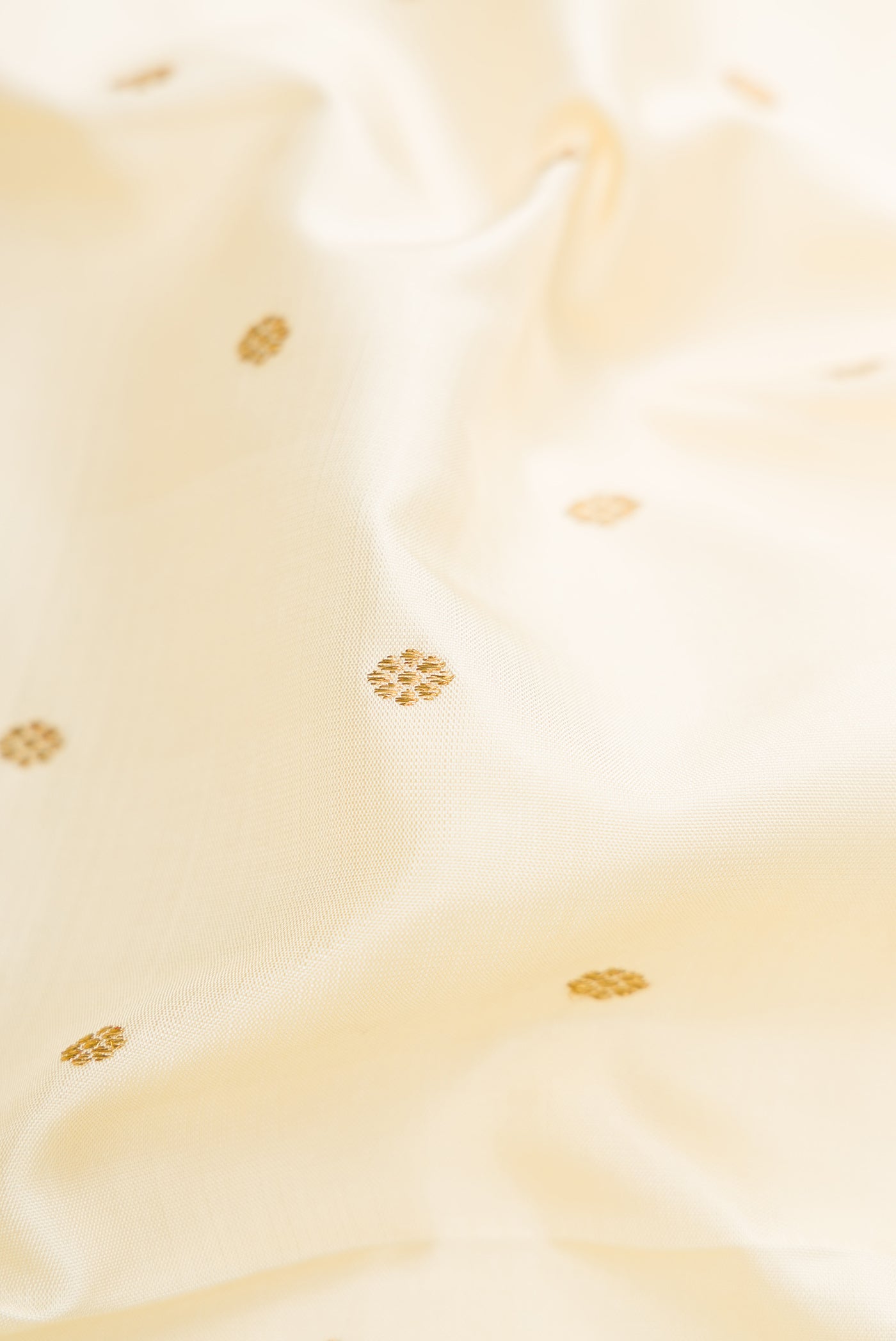 Close up of Pure Silk Pure Zari Off White Kanjivaram Saree with Zari Butta on the body and Zari Border.  displaying folds