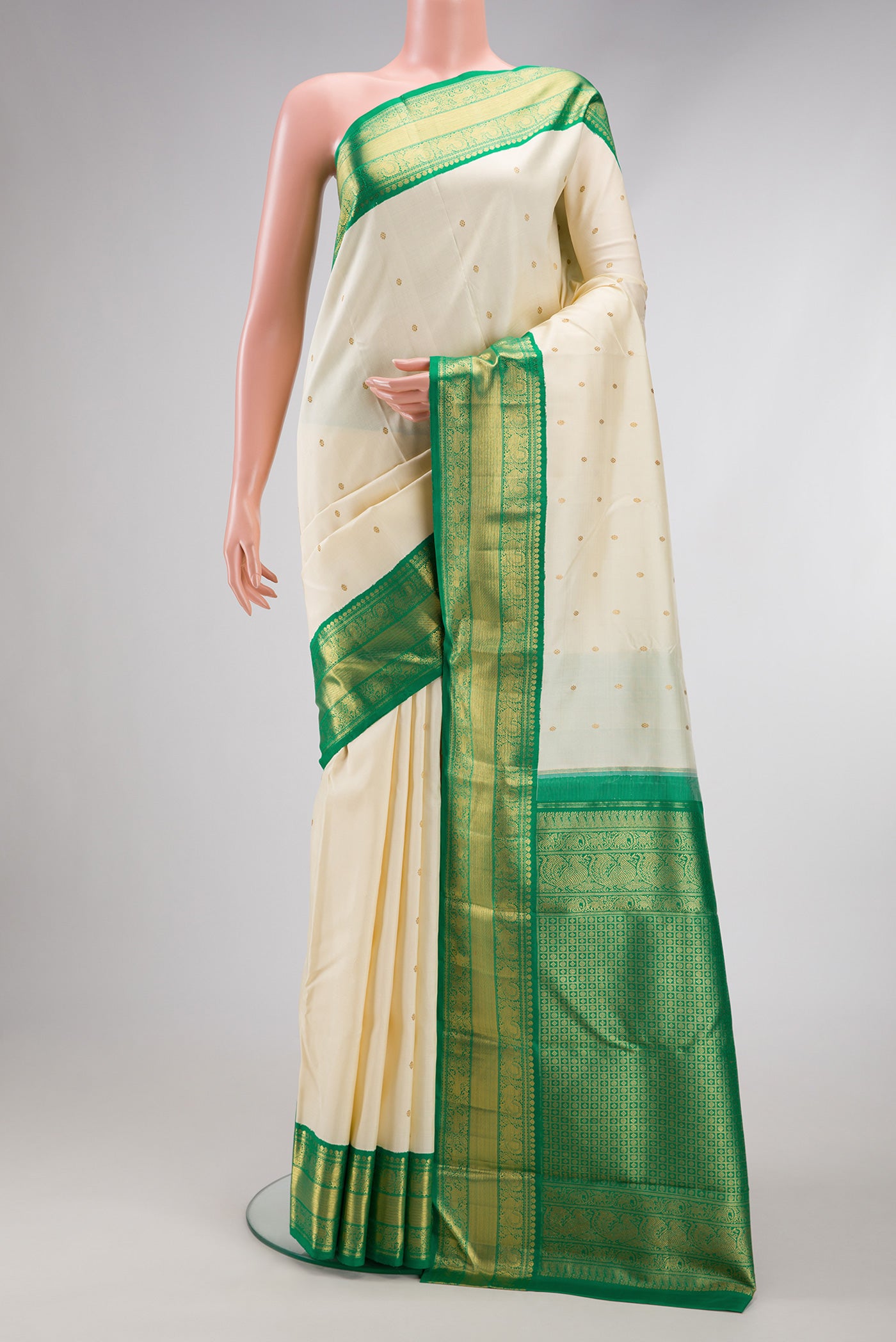 Pure Silk Pure Zari Off White Kanjivaram Saree with Zari Butta on the body and Zari Border.  displayed on a mannequin