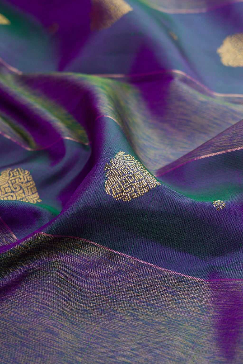 Close up of Pure Silk Pure Zari Peacock Blue Dual Tone Kanjivaram Saree with Zari Butta on the body and Fancy Border.  displaying folds