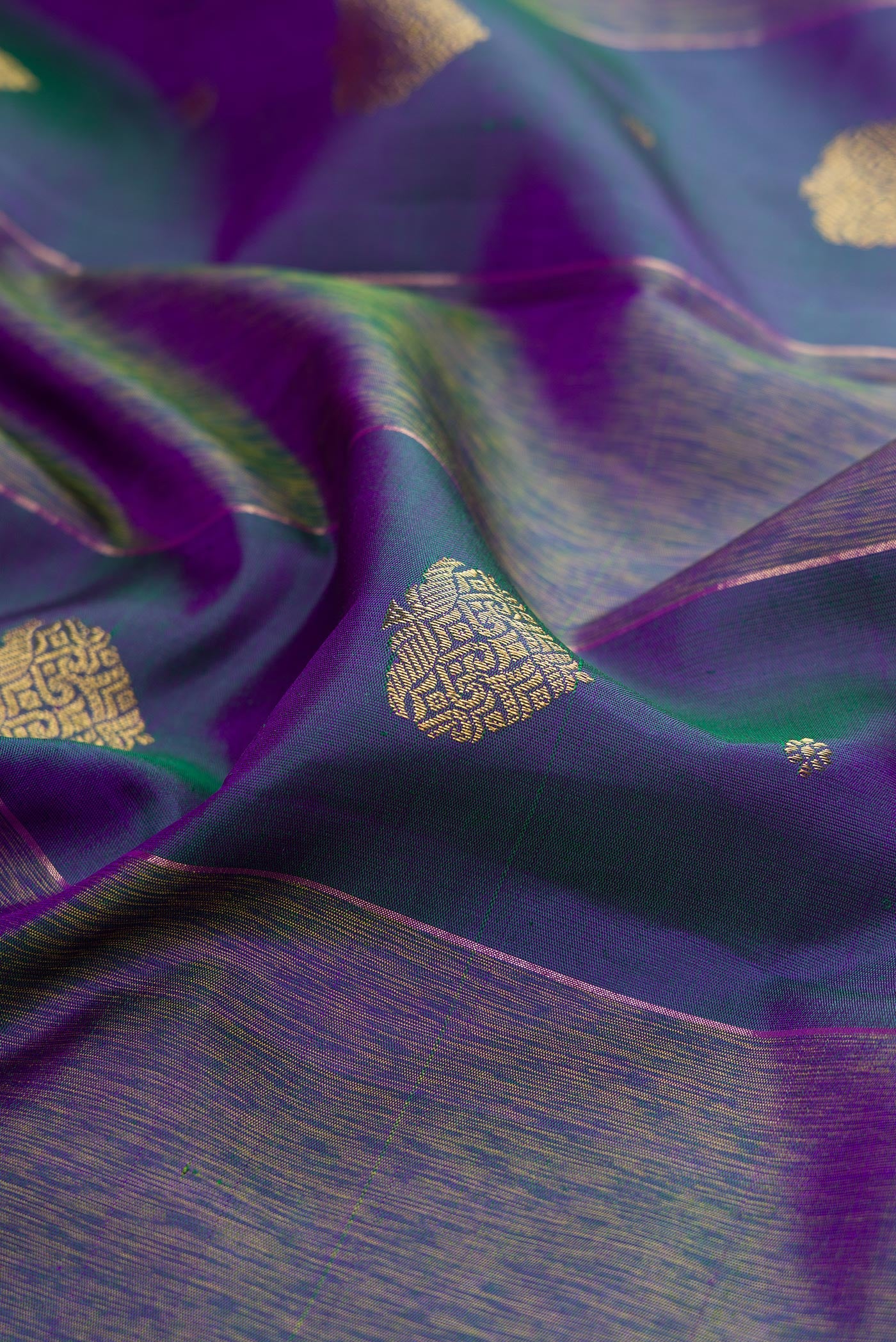 Close up of Pure Silk Pure Zari Peacock Blue Dual Tone Kanjivaram Saree with Zari Butta on the body and Fancy Border.  displaying folds